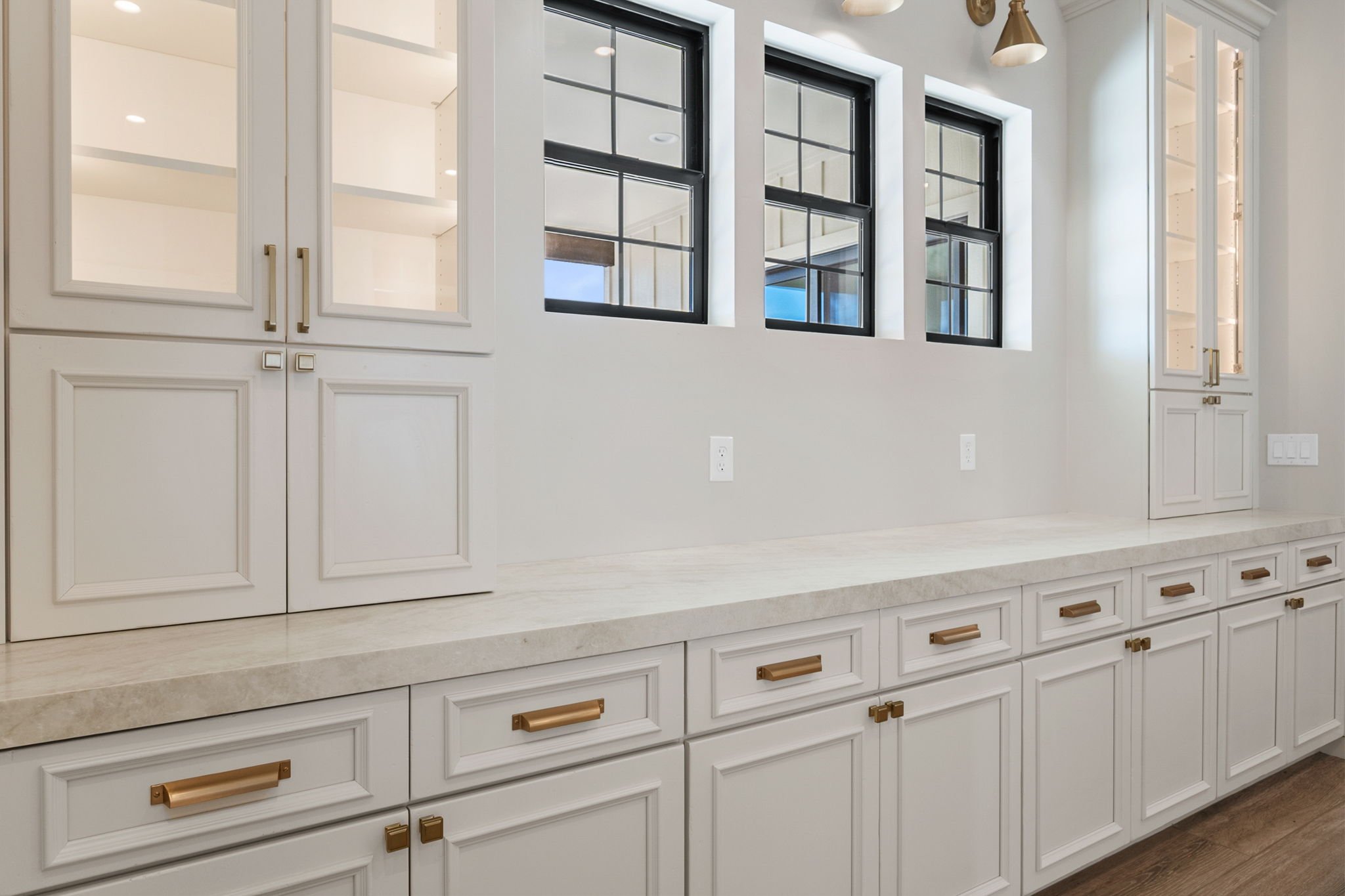 This custom kitchen features premium Shiloh Custom Cabinetry in a timeless Shoji White painted finish, paired with elegant honey bronze hardware from Top Knobs. Designed for both style and durability, this kitchen highlights clean lines, warm tones, 