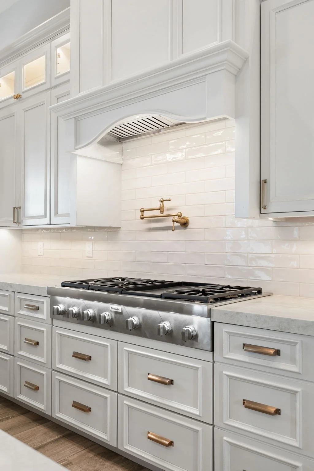 This custom kitchen features premium Shiloh Custom Cabinetry in a timeless Shoji White painted finish, paired with elegant honey bronze hardware from Top Knobs. Designed for both style and durability, this kitchen highlights clean lines, warm tones, 
