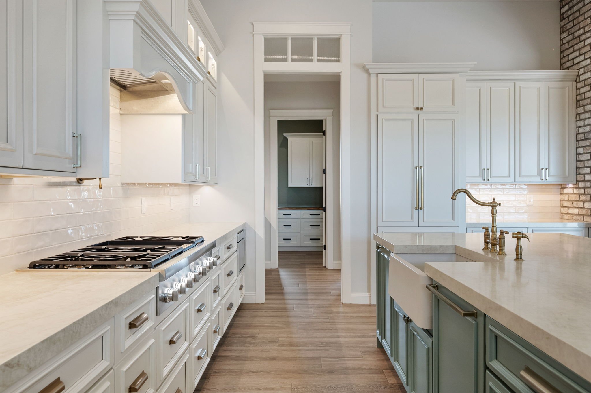 This custom kitchen features premium Shiloh Custom Cabinetry in a timeless Shoji White painted finish, paired with elegant honey bronze hardware from Top Knobs. Designed for both style and durability, this kitchen highlights clean lines, warm tones, 