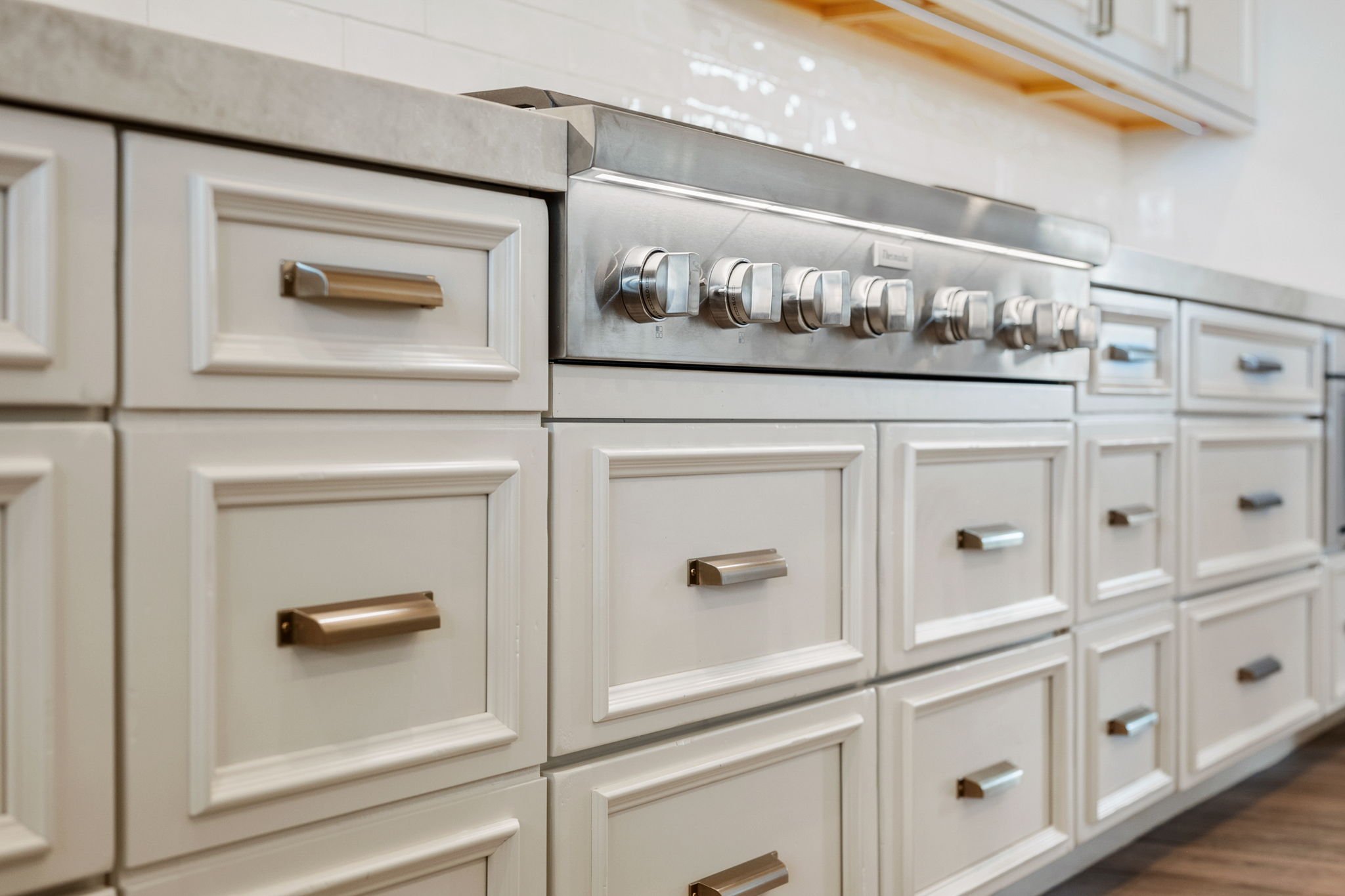 This custom kitchen features premium Shiloh Custom Cabinetry in a timeless Shoji White painted finish, paired with elegant honey bronze hardware from Top Knobs. Designed for both style and durability, this kitchen highlights clean lines, warm tones, 