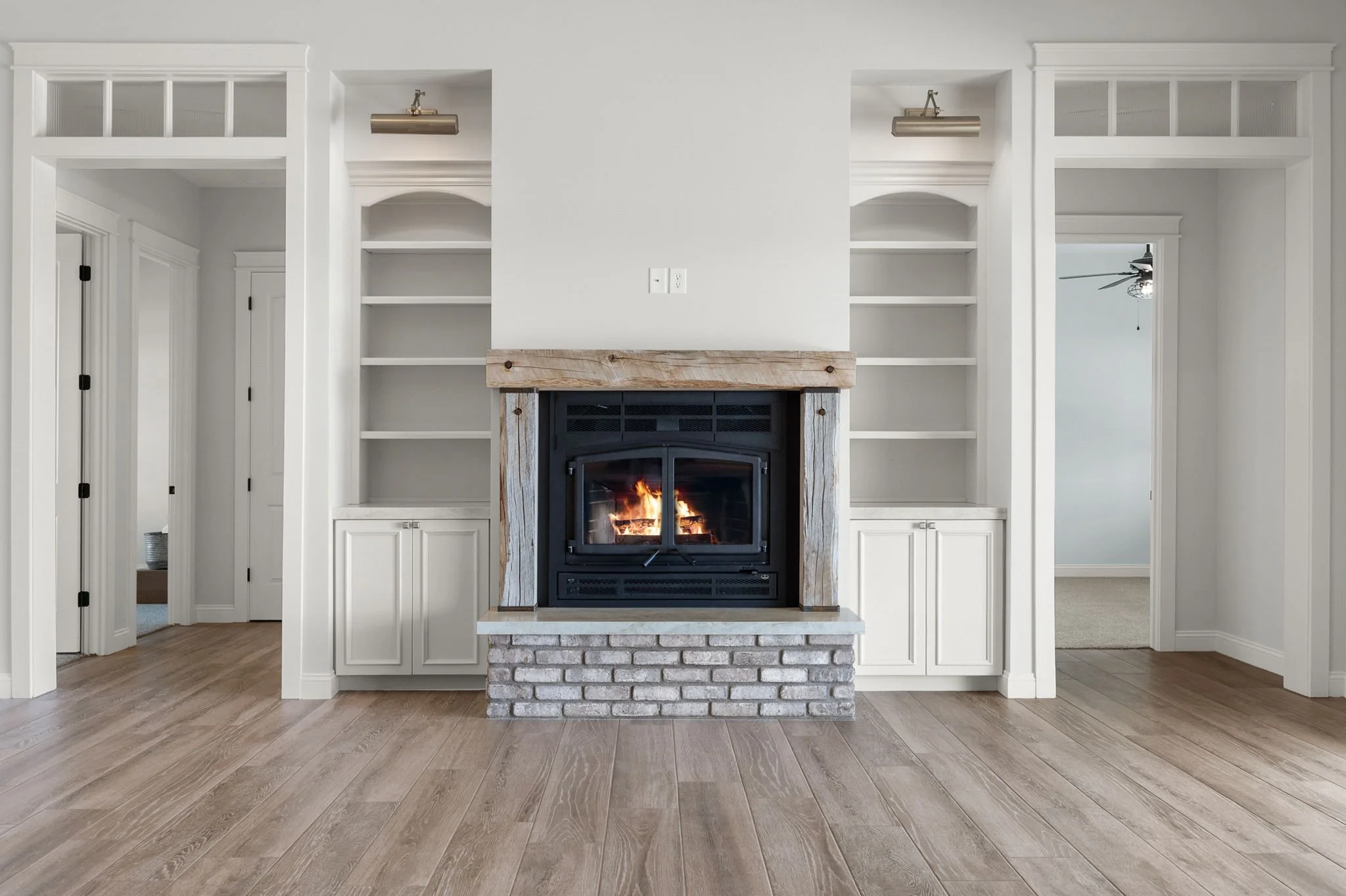 These custom built-in bookcases feature Shiloh Custom Cabinetry in a Shoji White painted finish, accented with premium honey bronze hardware from Top Knobs. Designed to seamlessly integrate into the home, these bookcases provide both functional stora