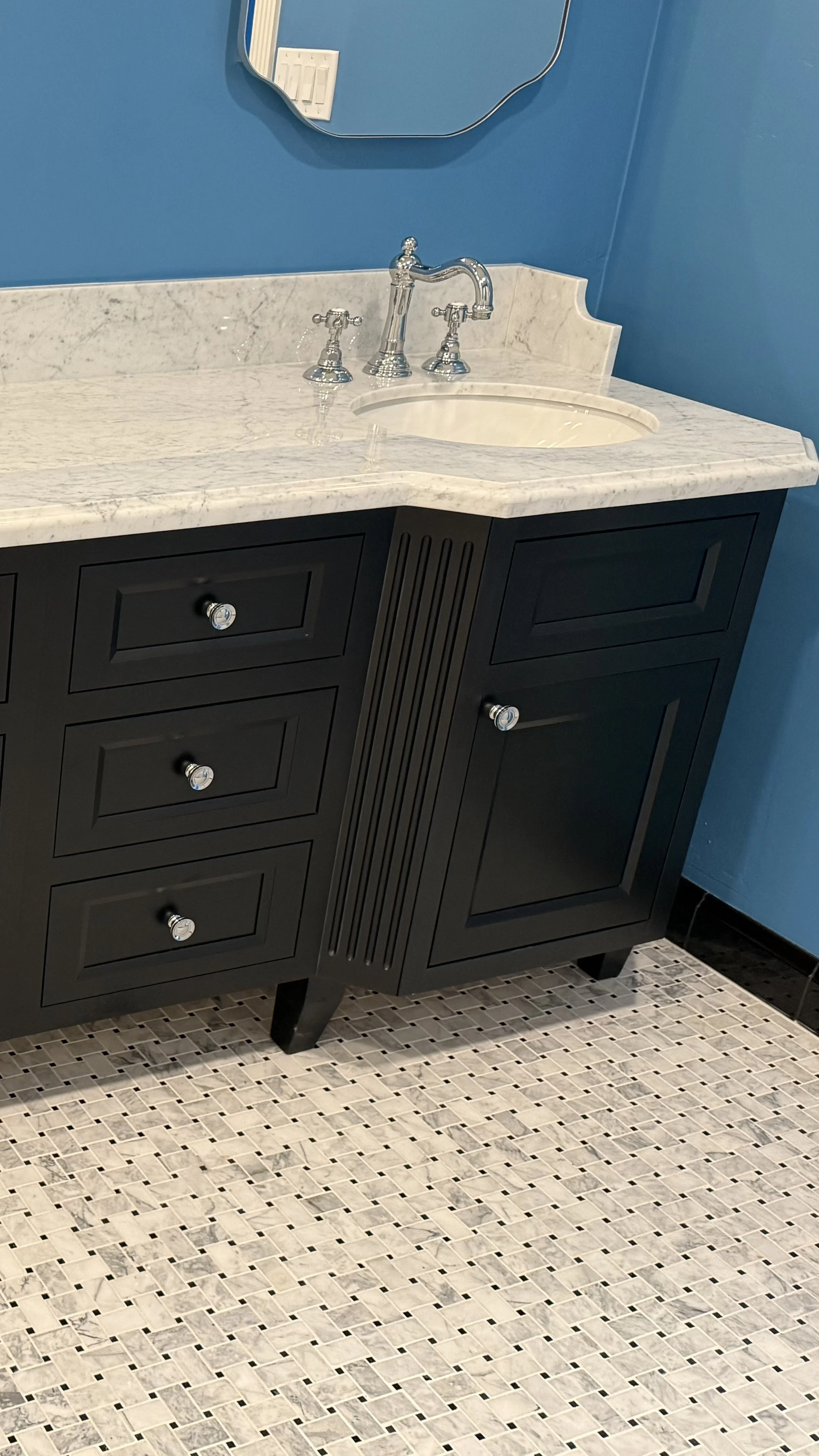 custom vanity cabinet featuring clipped fluted corners and top knobs hardware, made to look like furniture