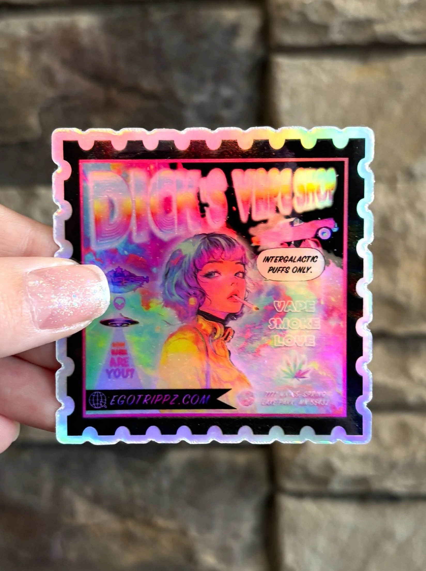 Holographic sticker featuring a woman with short hair smoking a vape, with a colorful background and various texts including "Dicks Vape Shop," "Intergalactic Puffs Only," and website "egotripzz.com".