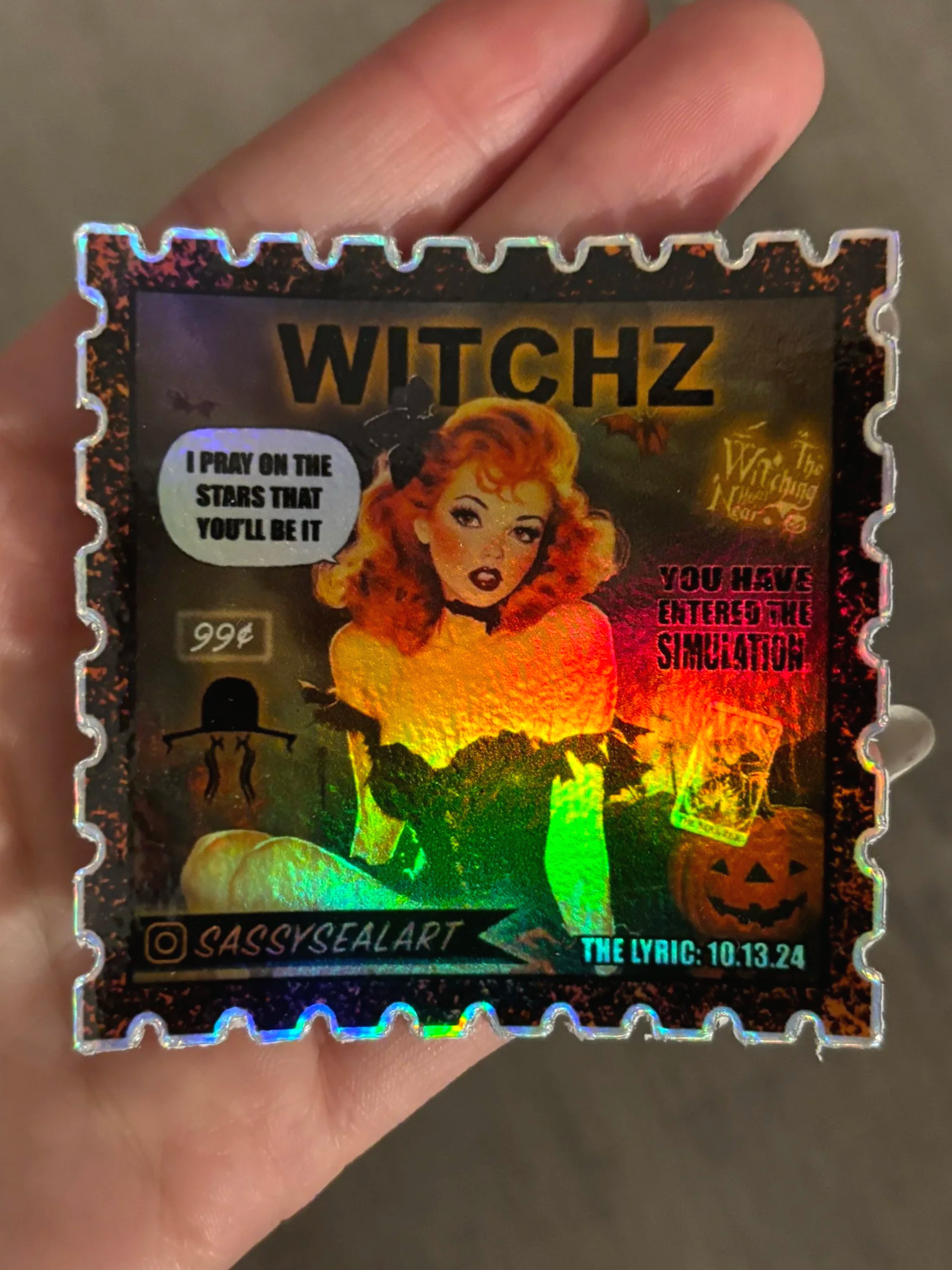 Holographic sticker with a witch theme, featuring a vintage-style illustration of a woman with curly orange hair, surrounded by Halloween elements like bats and pumpkins, and text including 'WITCHZ,' 'I PRAY ON THE STARS THAT YOU'LL BE IT,' and 'YOU 