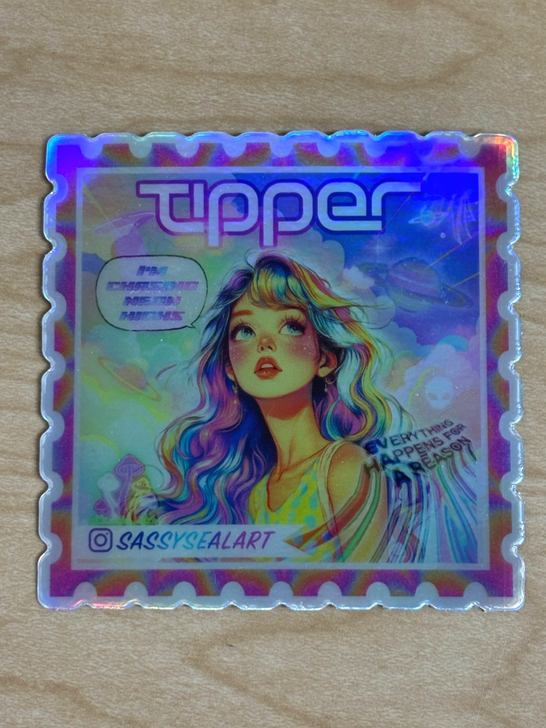 Holographic sticker with a colorful illustration of a woman with long, wavy hair, the word "Tipper" at the top, and the Instagram handle "@sassysealart" at the bottom