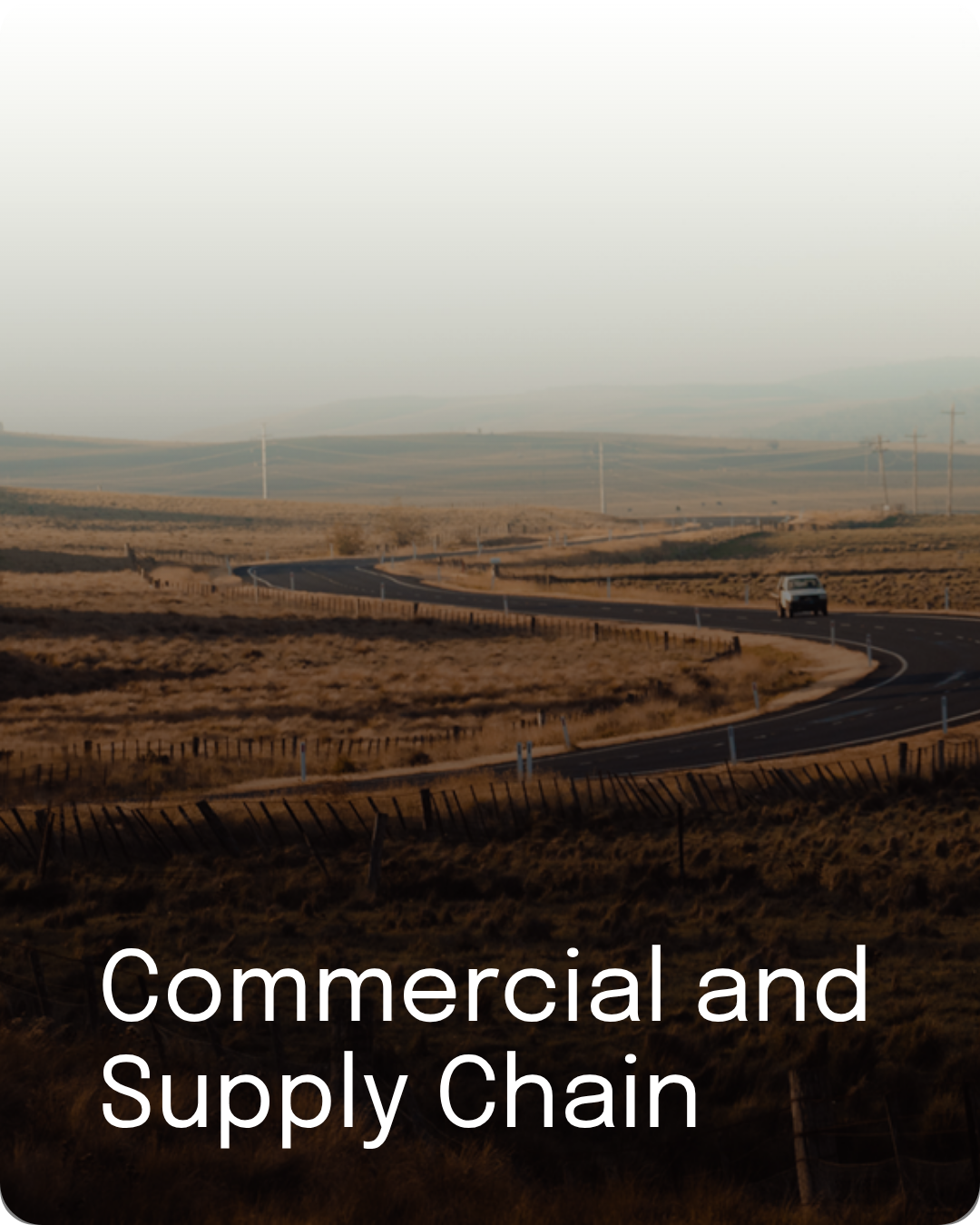 Winding regional road through open rural landscape, representing commercial and supply chain work.
