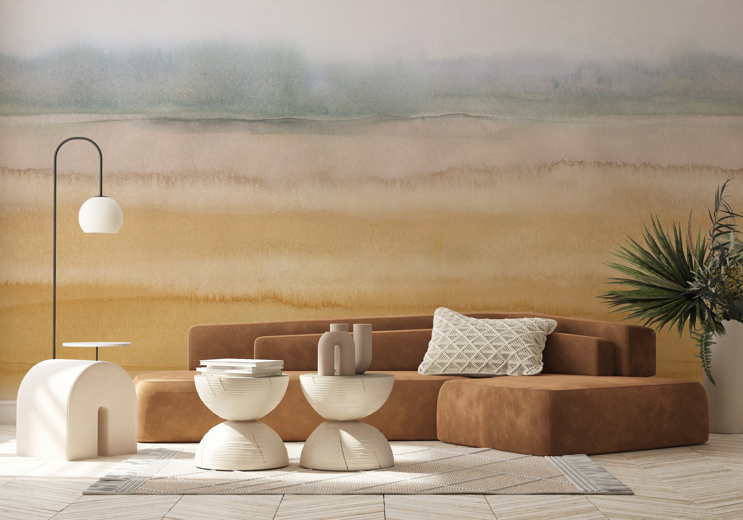 Modern living room with a warm brown velvet sectional, sculptural cream tables, and a watercolor-inspired landscape wall mural in soft desert tones