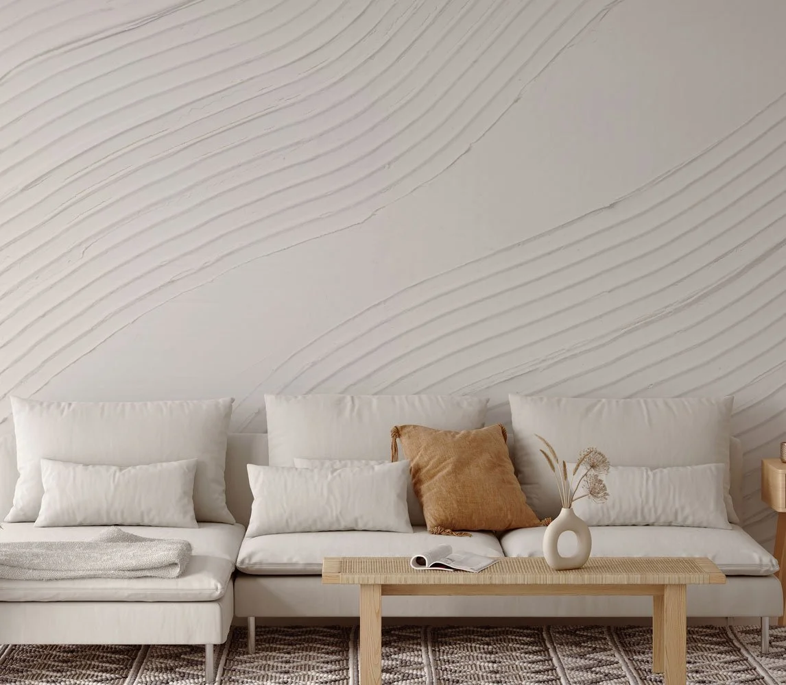 Neutral-toned modern living room featuring a textured wallcovering with sweeping, sculptural plaster-like curves from the Terrene collection.