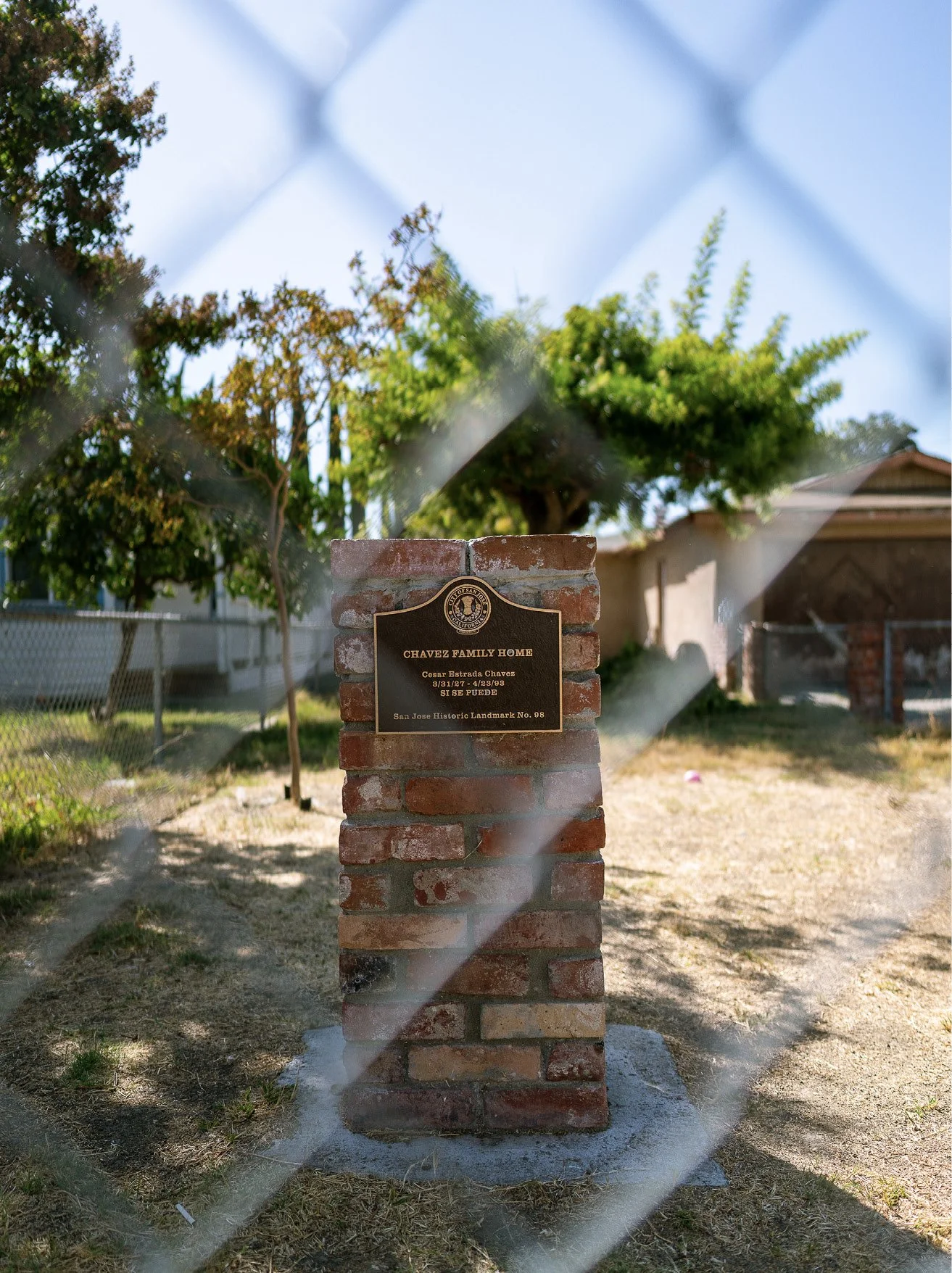 A brick pillar that reads: "CHAVEZ FAMILY HOME. Cesar Estrada Chavez. 3/31/27 - 4/23/93. SI SE PUEDE. San Jose Historic Landmark No. 98
