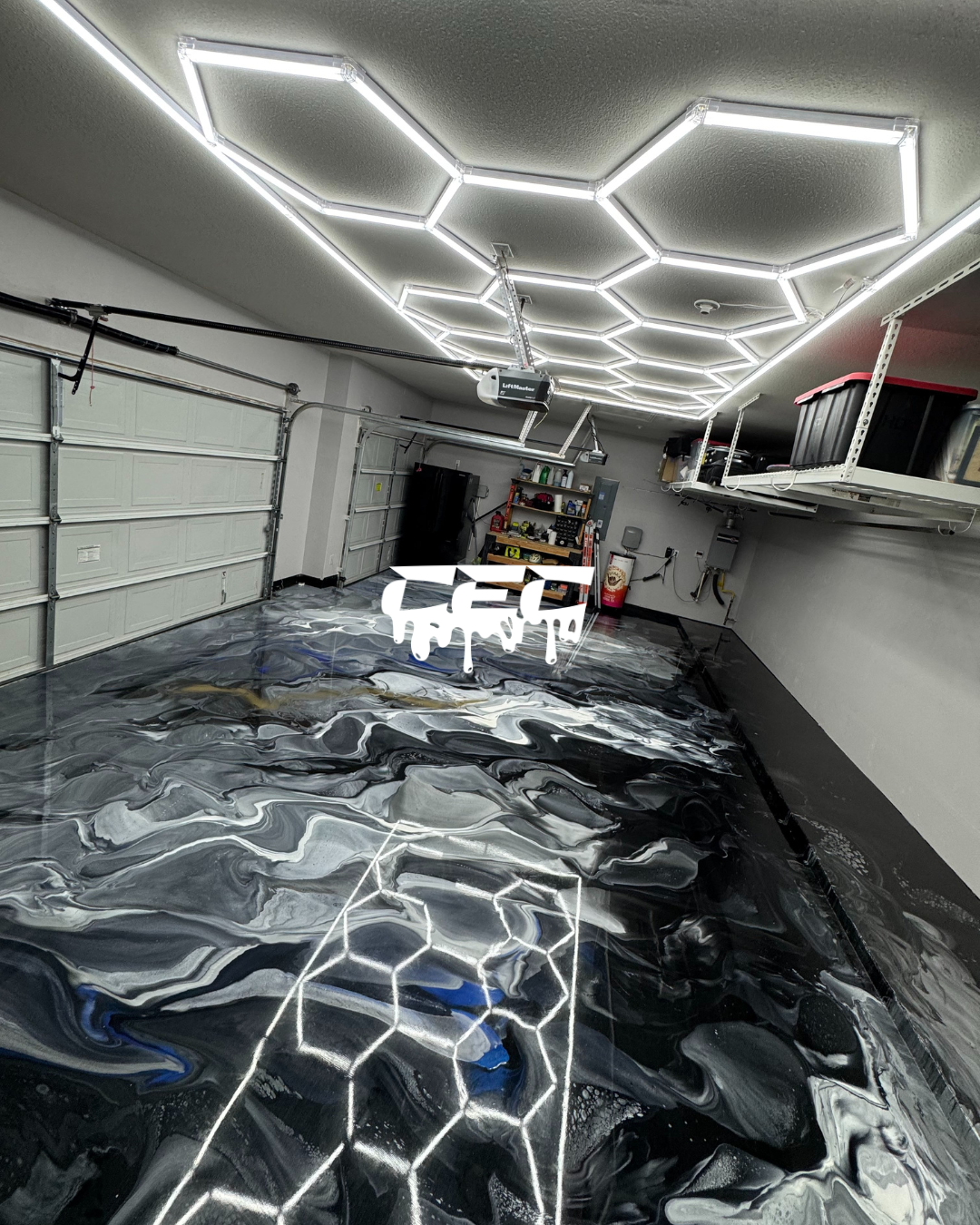A garage with a geometric, hexagon-shaped LED ceiling light installation, a garage door, shelves with tools, and a reflective, marble-like floor with a digital art overlay of dripping text.