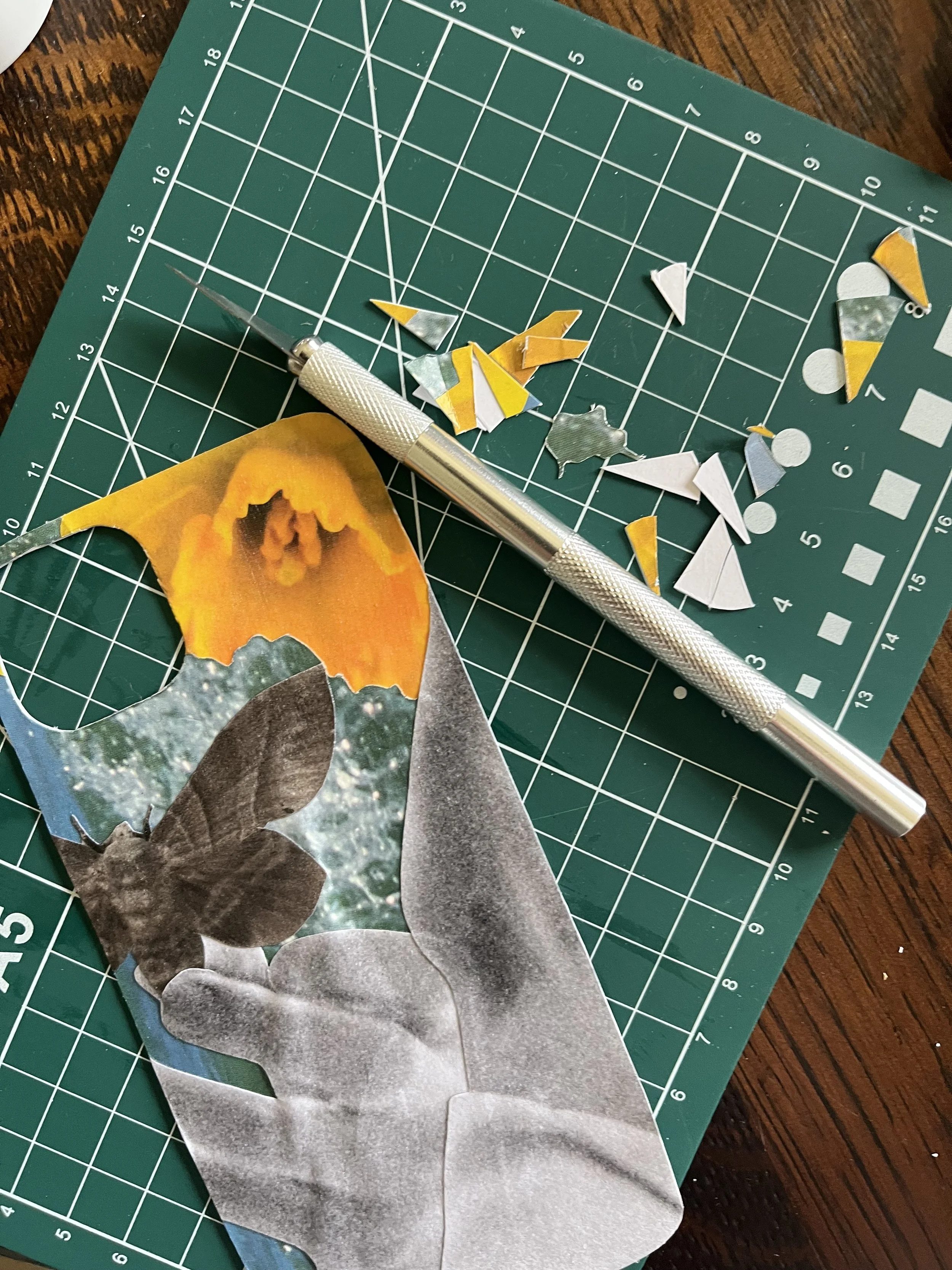 Collage workspace featuring paper cut-outs, a cutting mat and a craft knife. The collage is for a bespoke phone case.