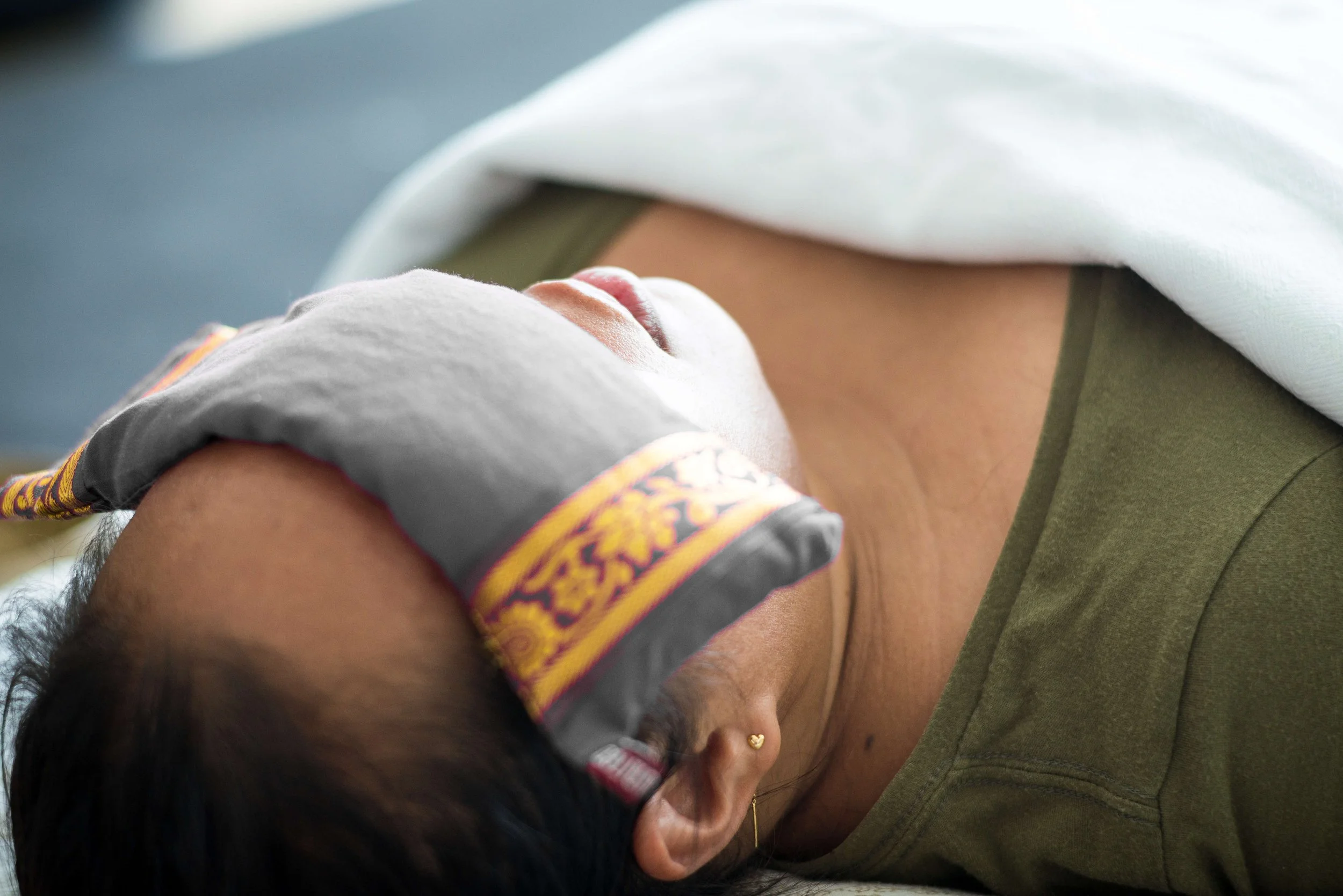Stacked smooth stones of varying sizes and colors on a large granite rock near a river or beach.