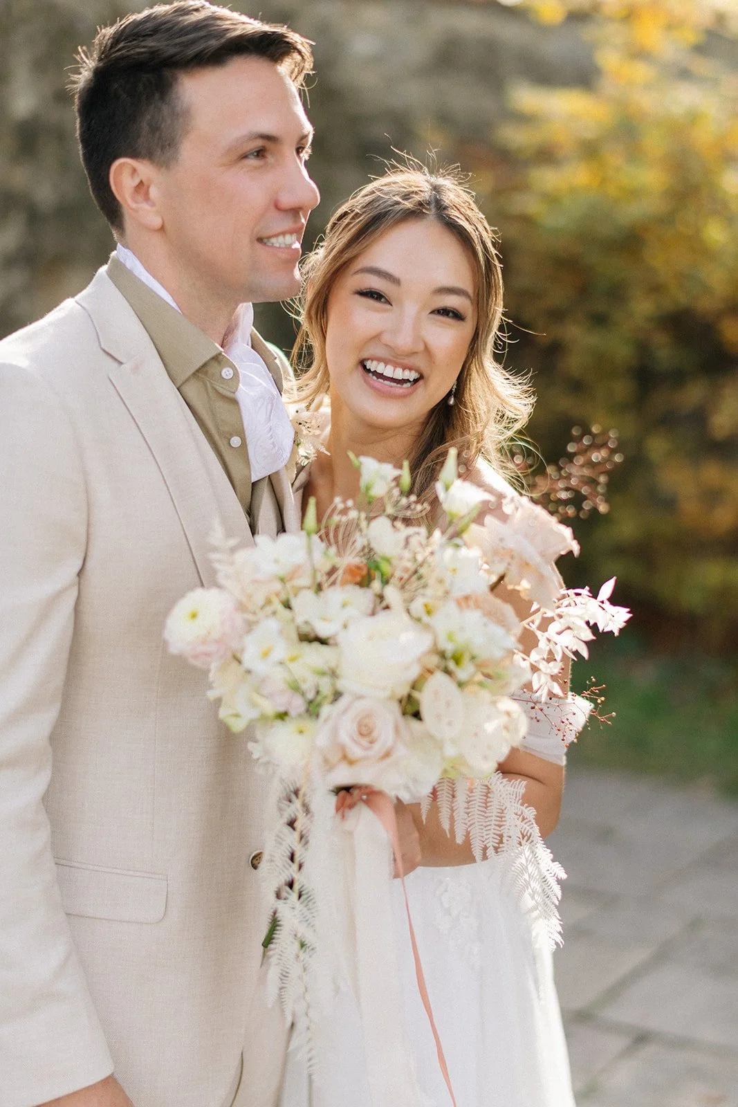 Two women, one with light brown hair and the other with short dark hair, engaged in conversation indoors, both holding smartphones.