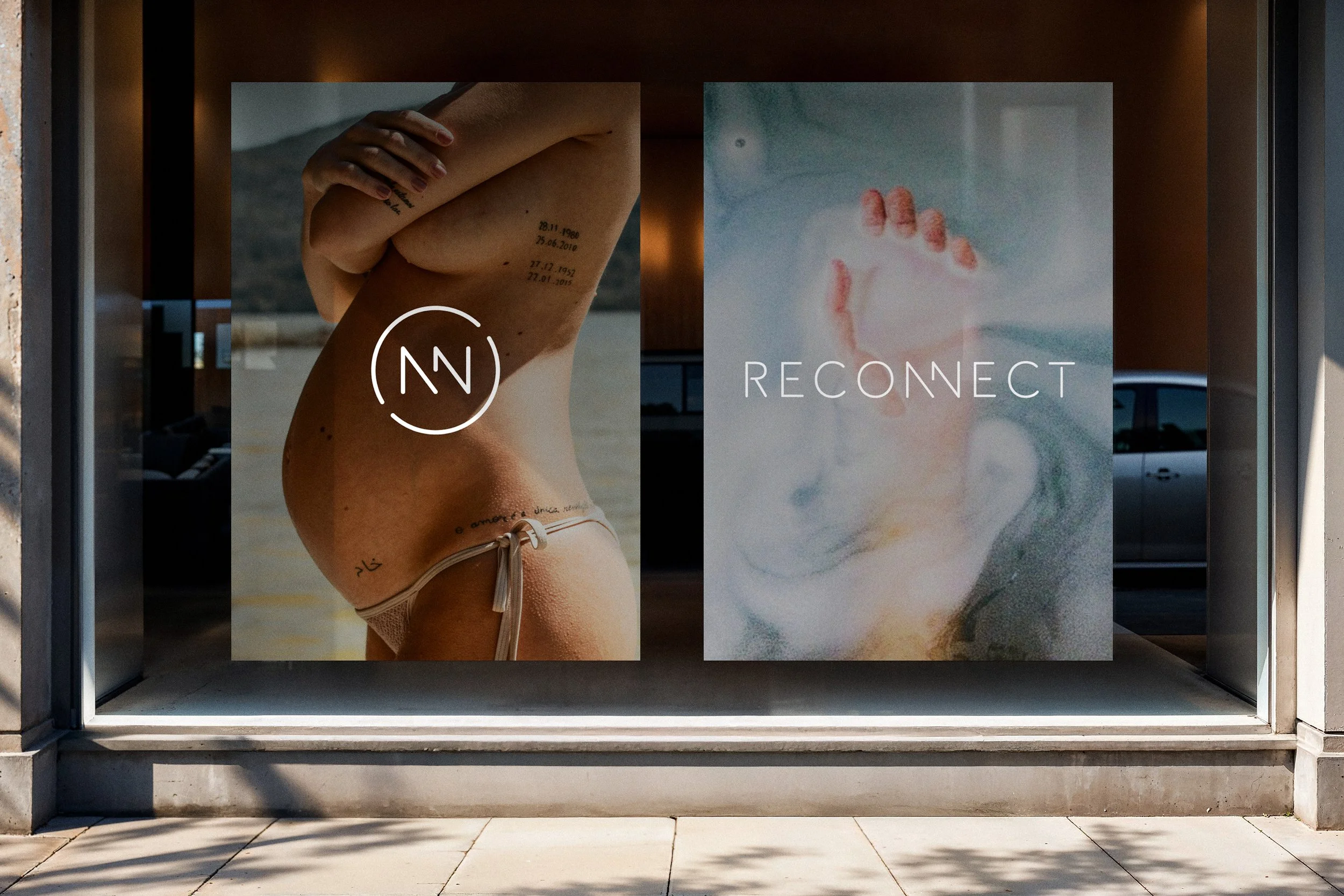 Storefront window displaying an advertisement with a woman's side profile and tattooed arm on the left, and an abstract image with a hand and healing symbols on the right, with the words "RECONNECT" in the center.