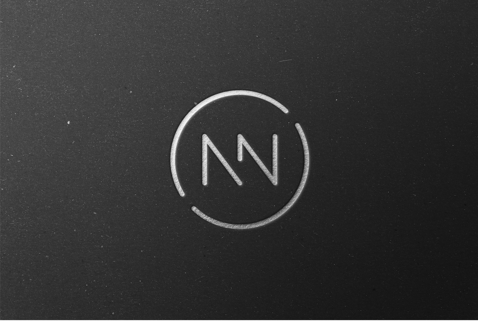 A black and white circular logo with a stylized letter 'N' in the center, and two curved lines partially enclosing the circle.