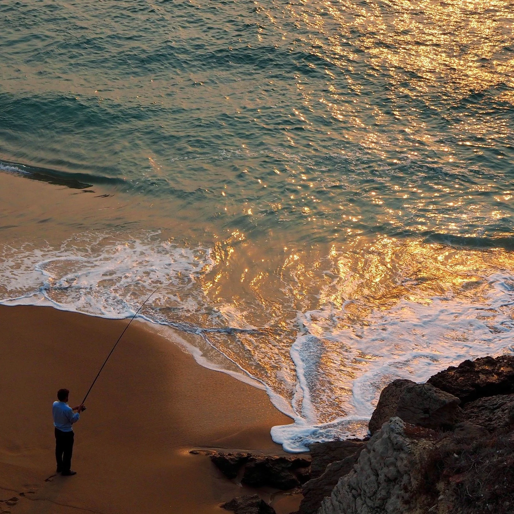 Evenings in Portugal - fishing after work

A photo taken during a trip to Portugal whilst I was in the midst of deciding whether to move to Lisbon or not. This man went some way to convincing me: a life that allows for fishing on a beautiful empty be