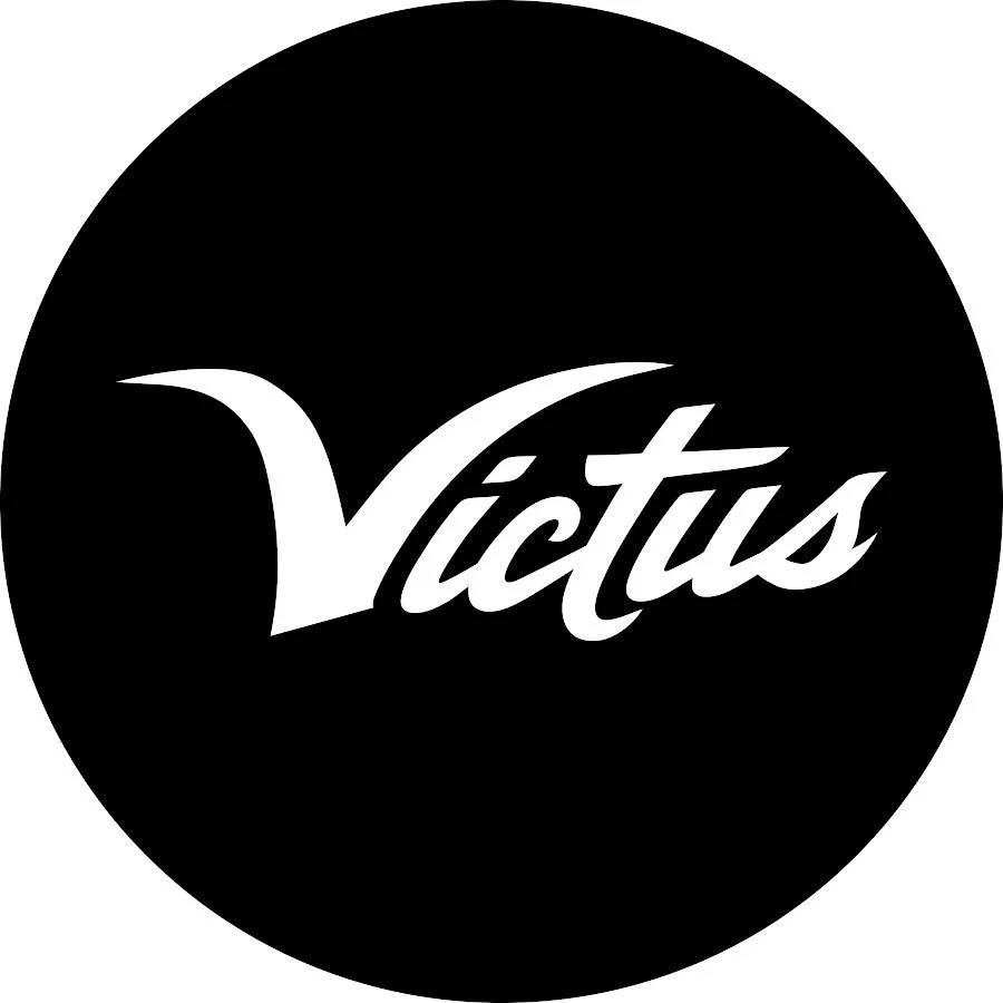 A black circular logo with the word "Victas" written in stylized white font.
