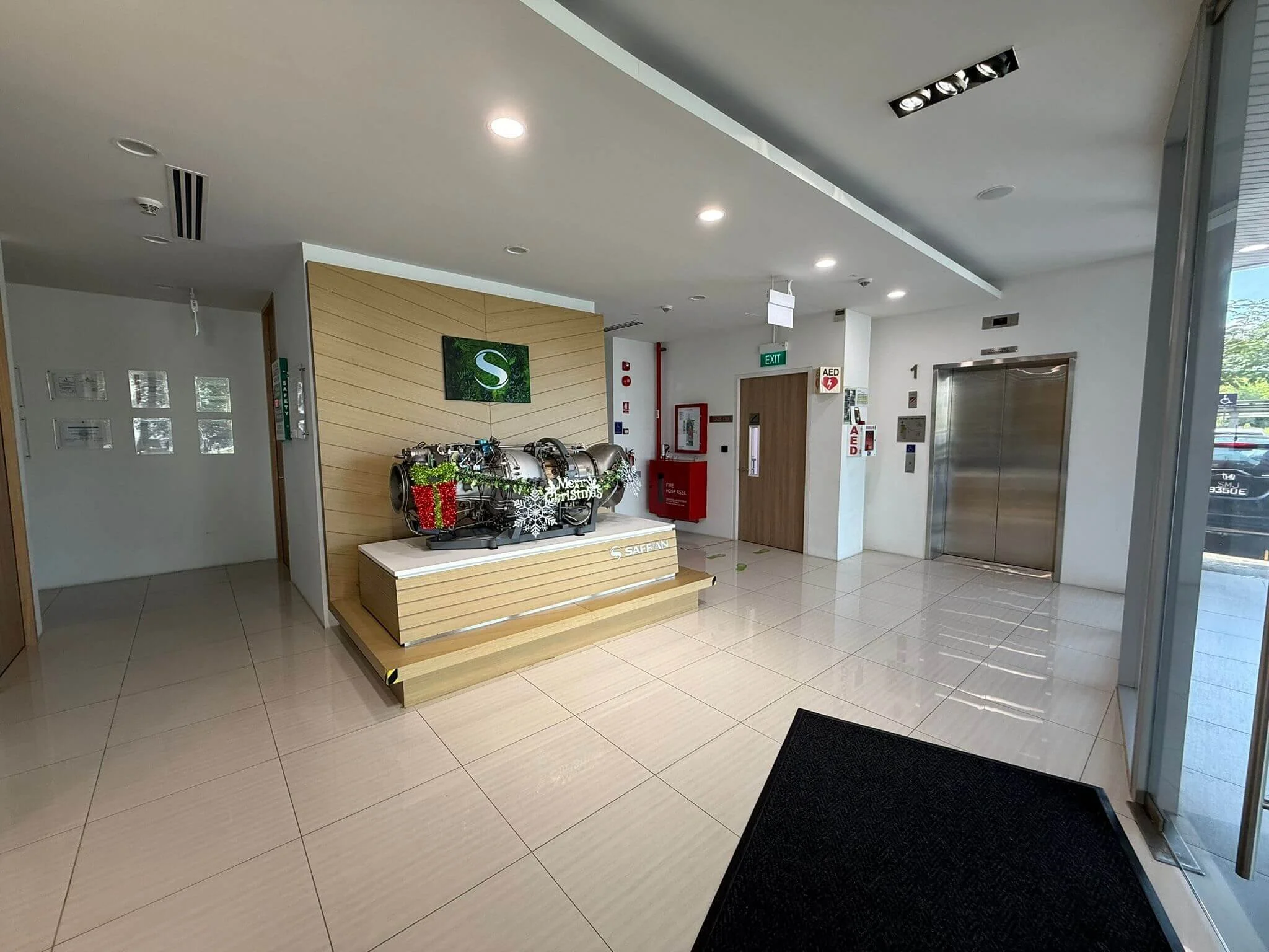 Lobby area with elevator, Christmas decorations, and a machine for recycling bottles in a modern building.