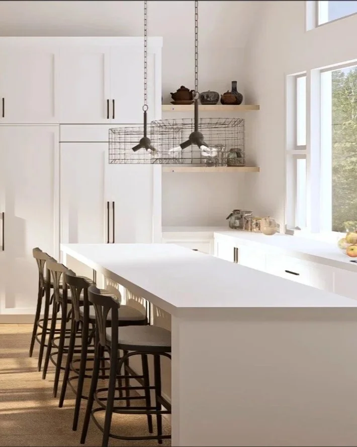 White modern kitchen with a large island, black chairs, open shelving with decor and utensils, and large windows letting in natural light.