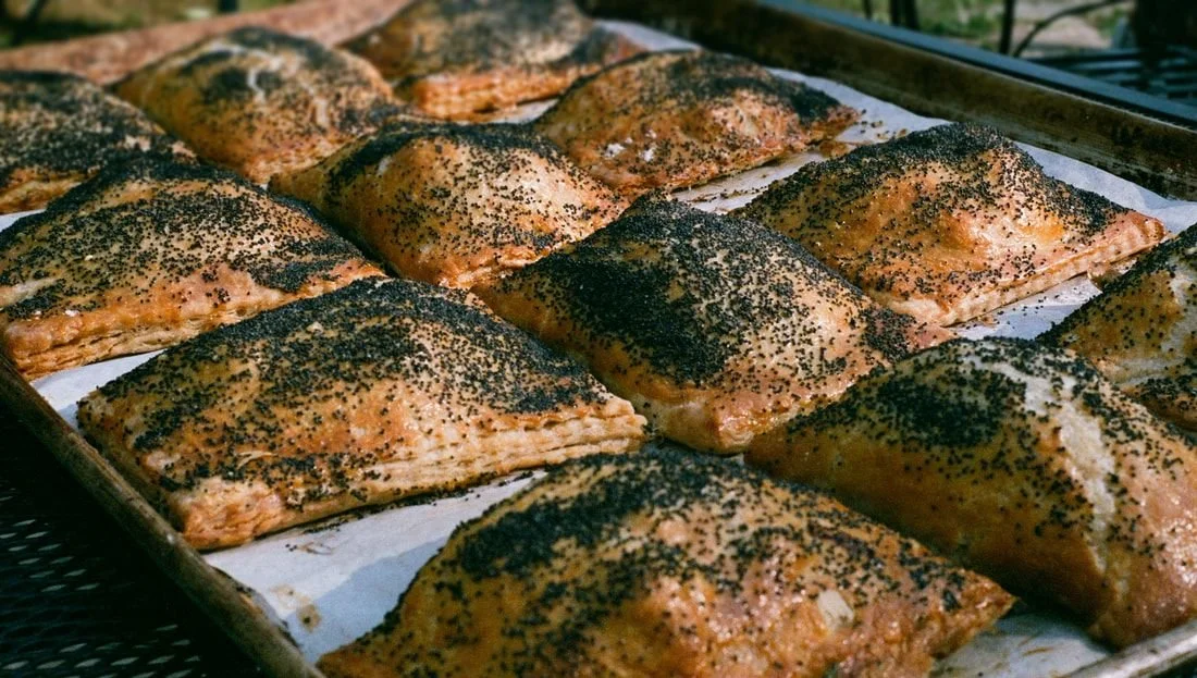 Baked salmon fillets topped with black sesame seeds on a baking sheet.