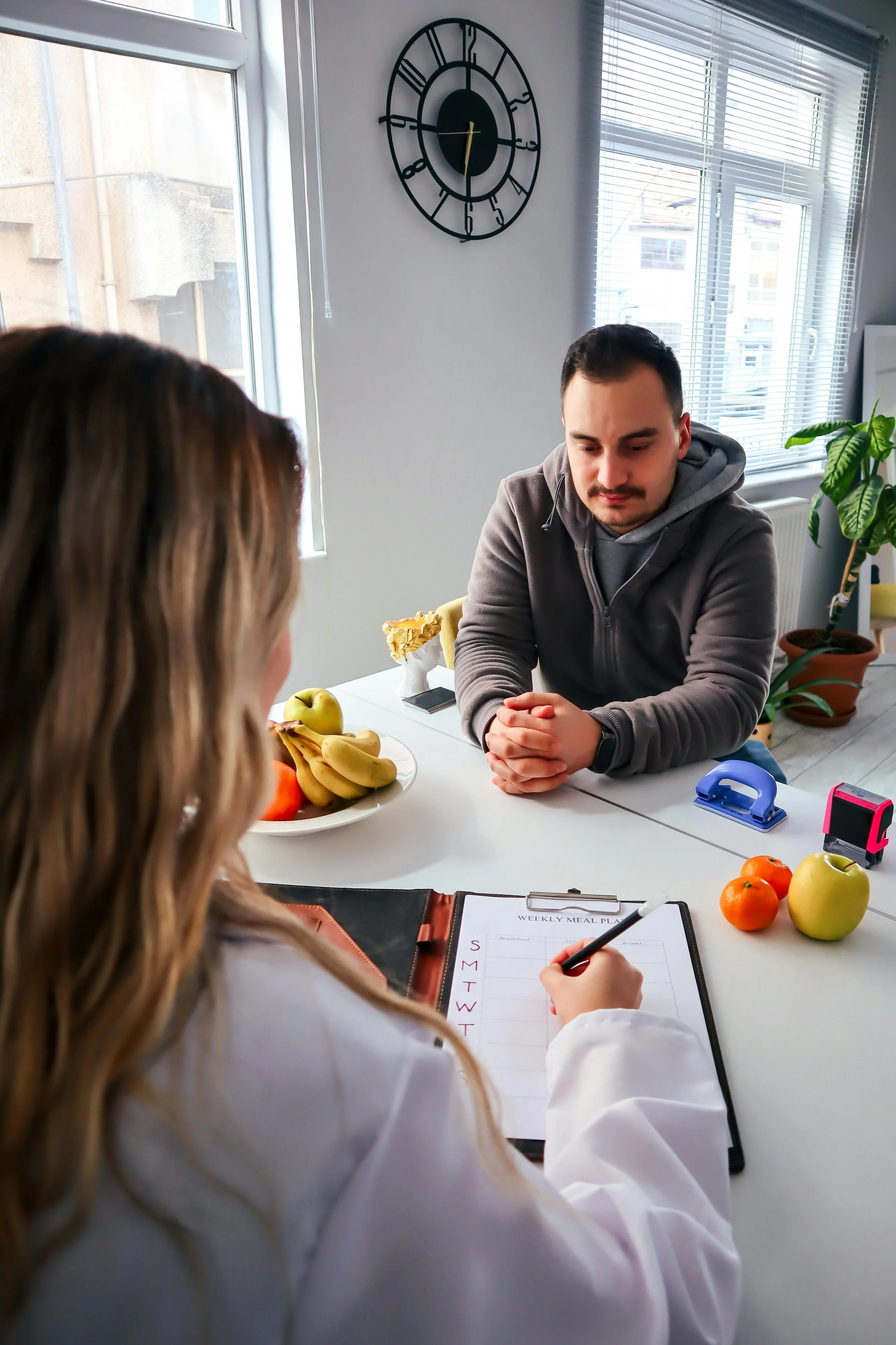a dietitian and client having a meeting, the dietitian is taking notes