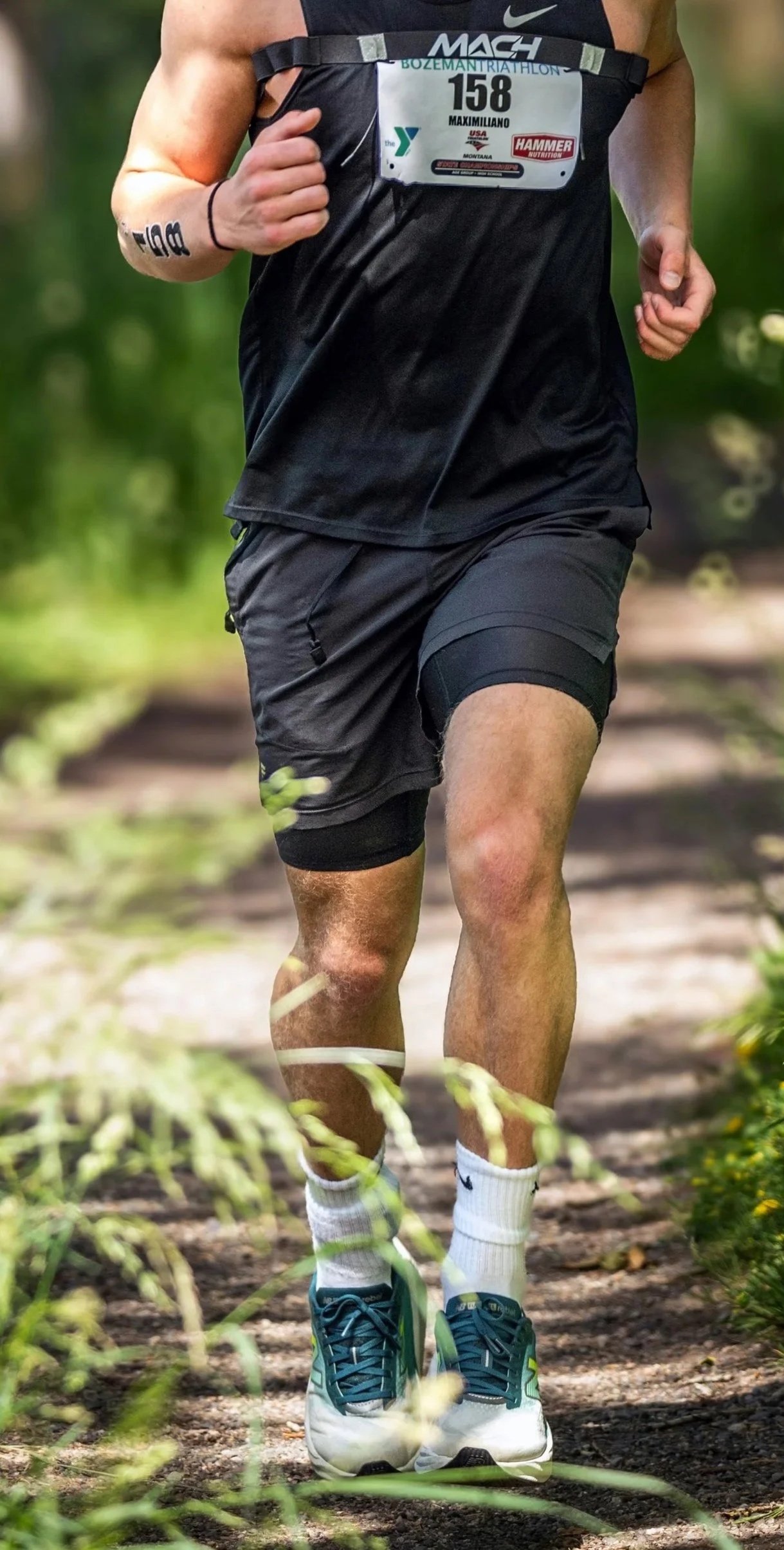a muscular man in athletic clothing running outdoors
