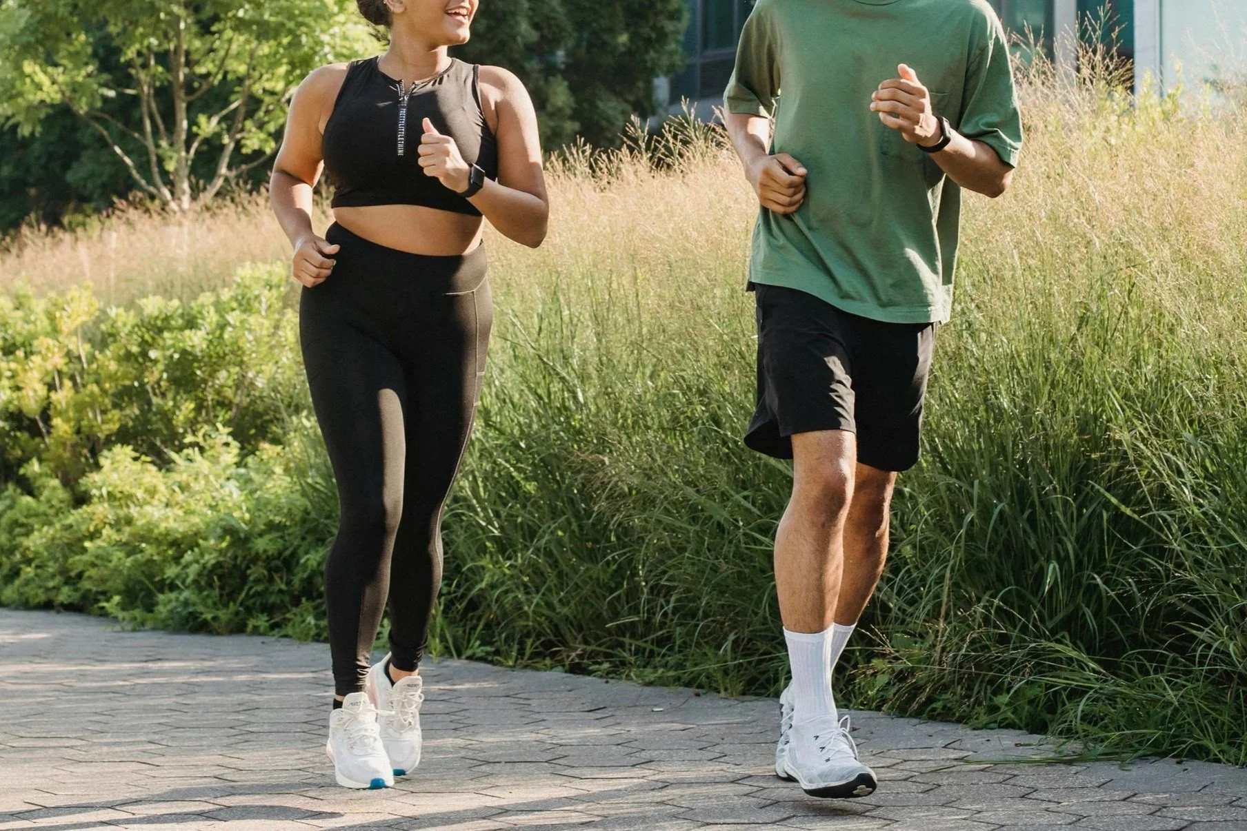 a man and woman happily running next to each other outdoors