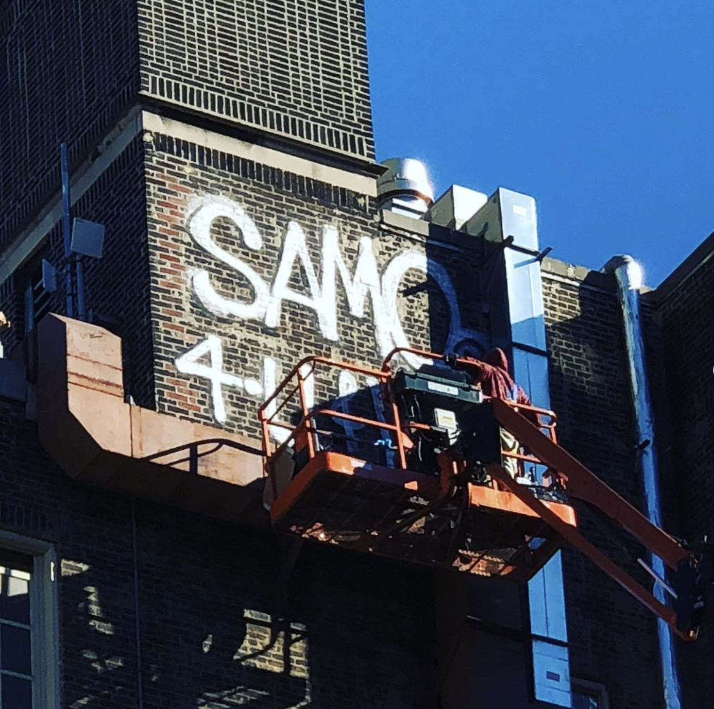  Crane restoring SAMO graffiti on City-As-School exterior. 