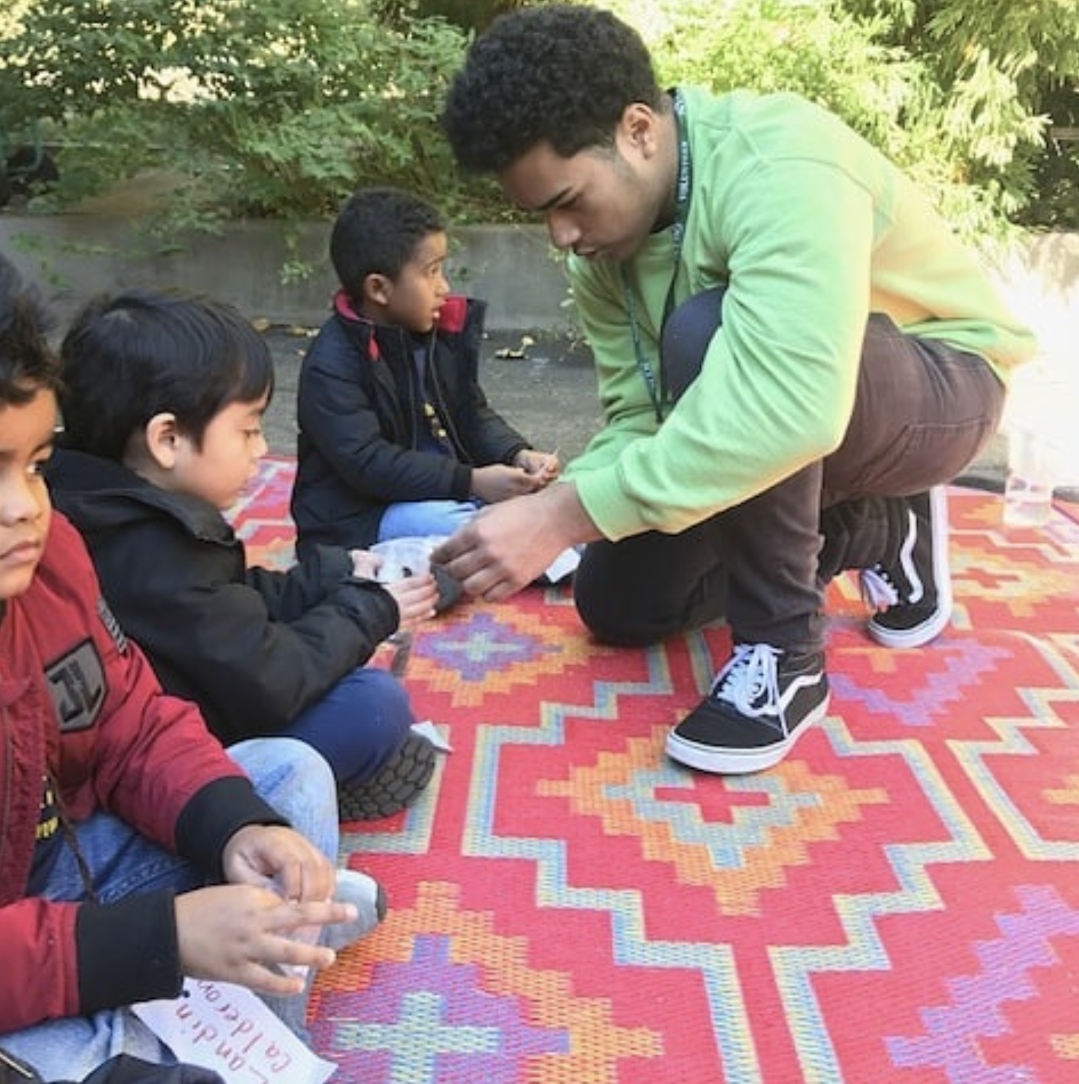  City-As-School students working with young children in park setting. 