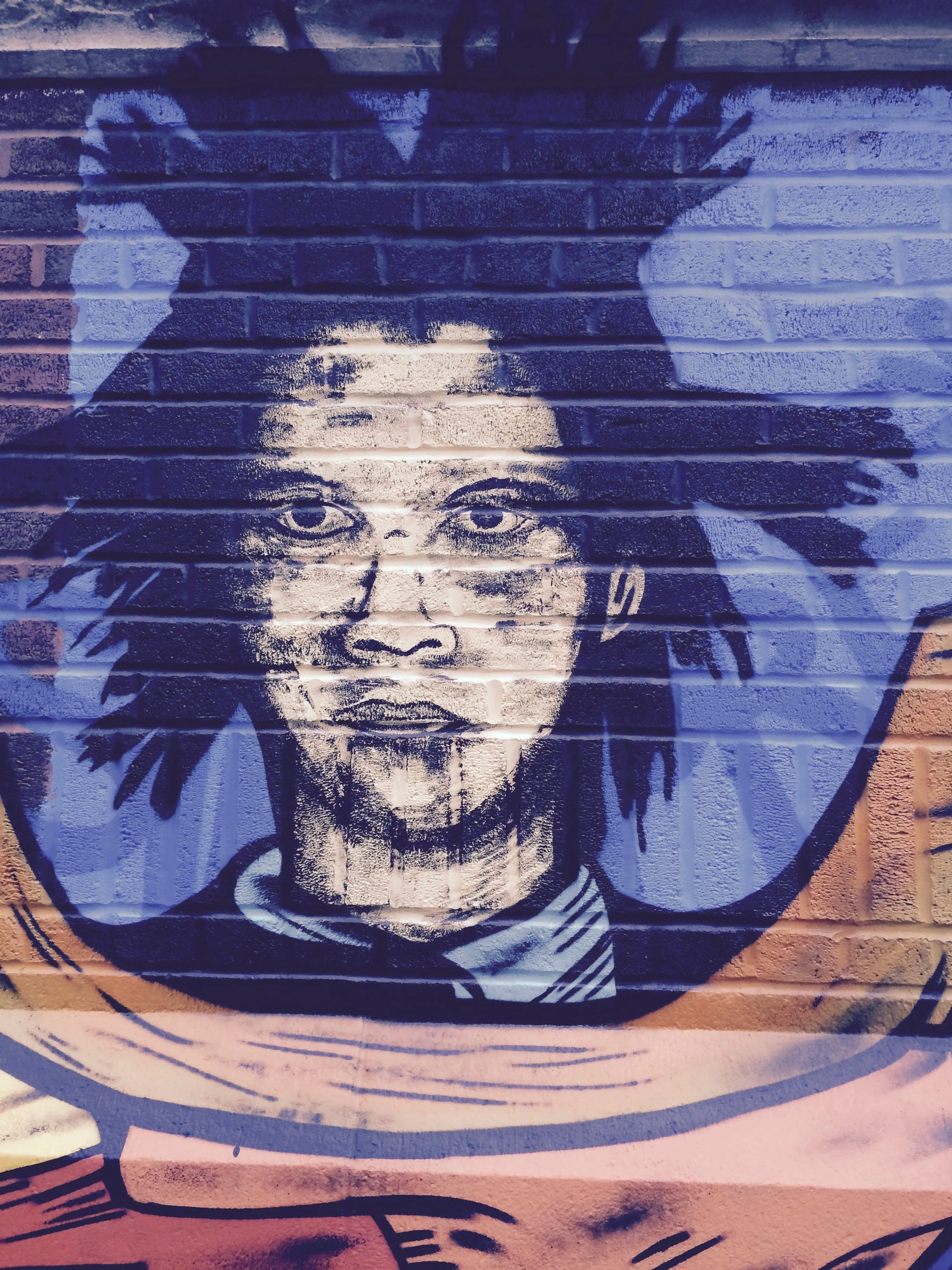  Colorful mural of Jean-Michel Basquiat on City-As-School exterior. 