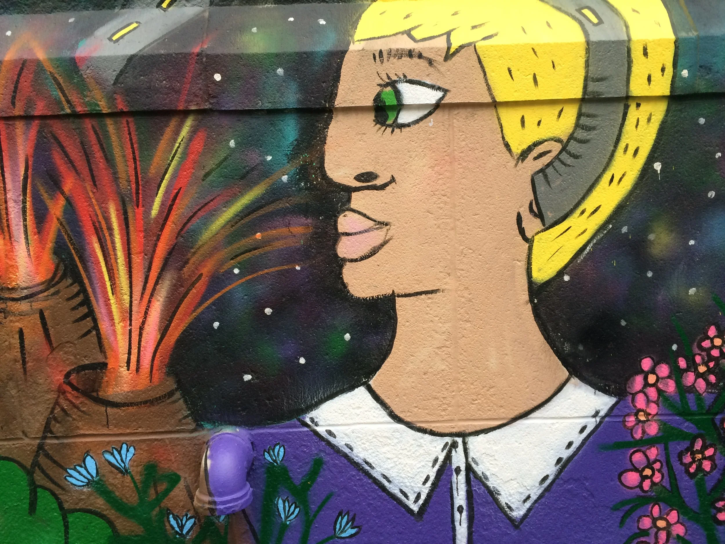  Colorful mural of young person and volcanos against night sky at City-As-School . 