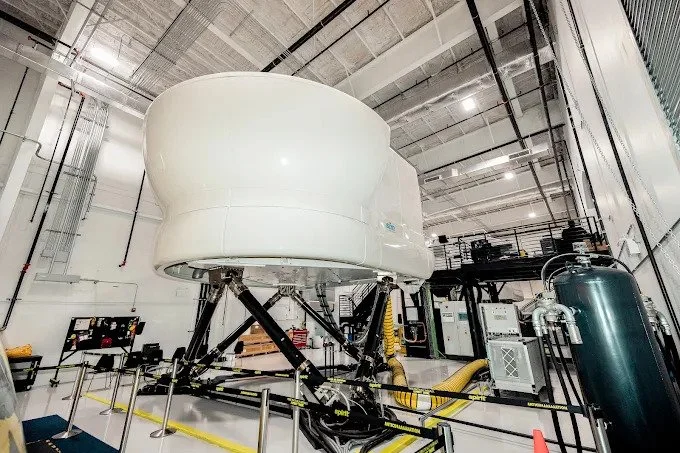 A large, complex flight simulator with various screens and controls, indicating advanced training facilities.