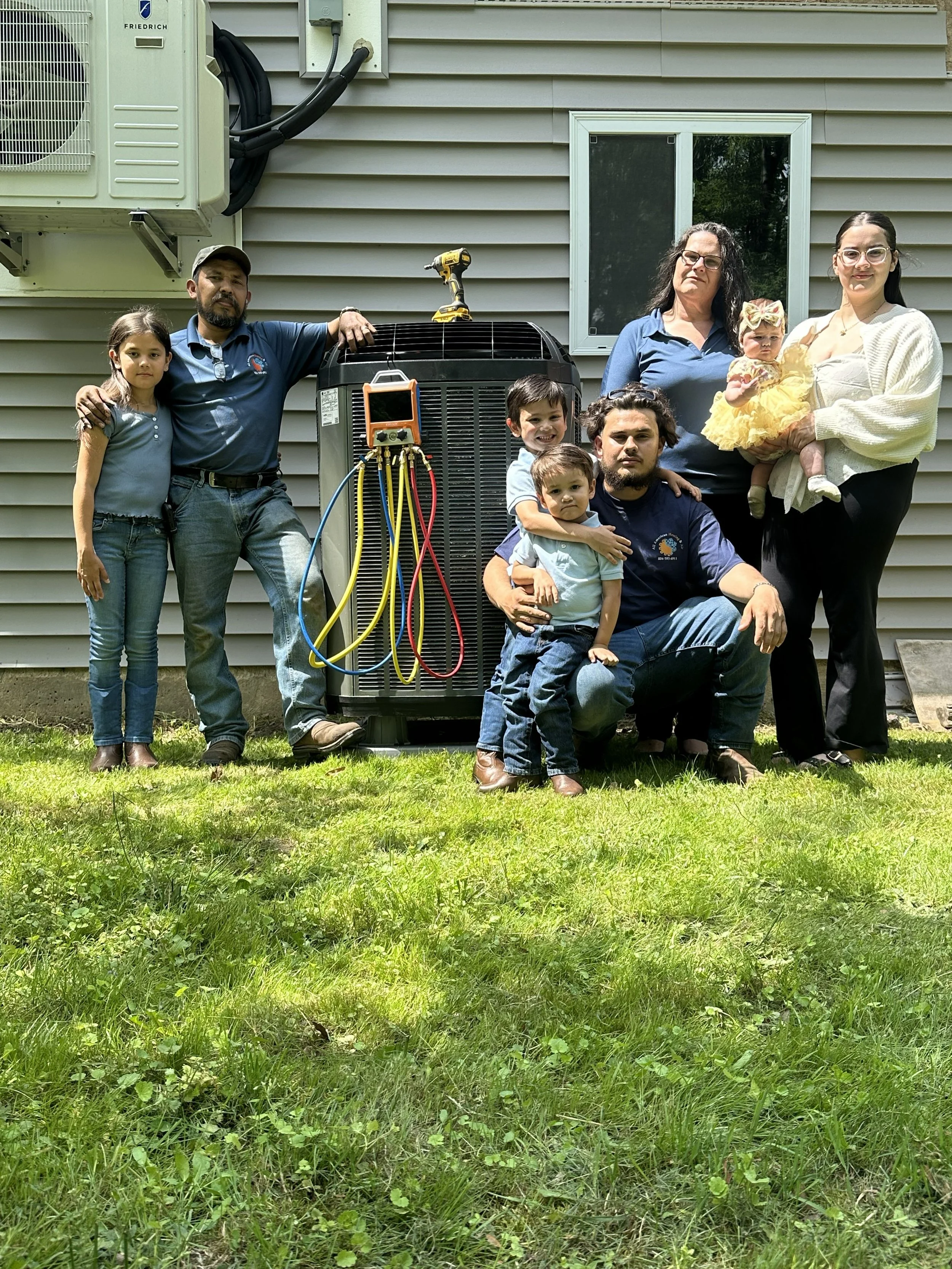 The family team behind All American Heating & Air standing together outside a residential home in Ashland, Virginia.