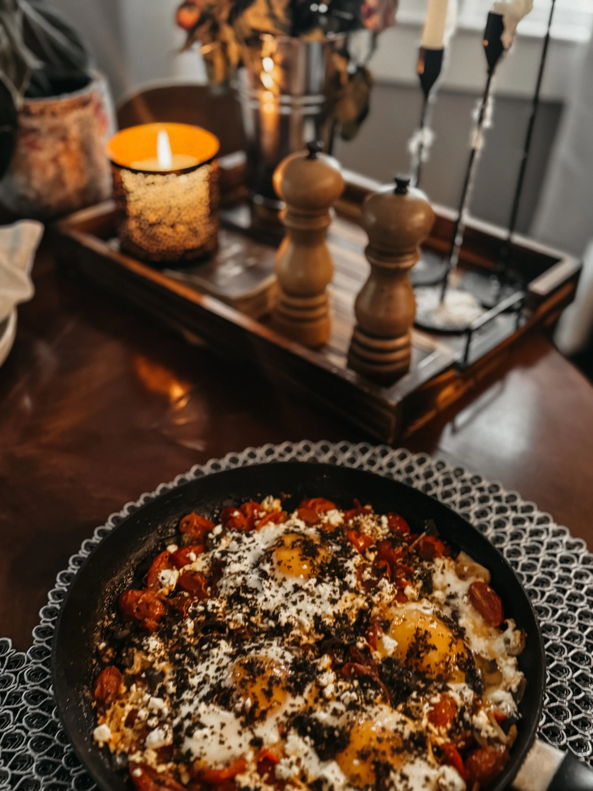 A skillet of strawberry shortcake with eggs on top, topped with black pepper and herbs.