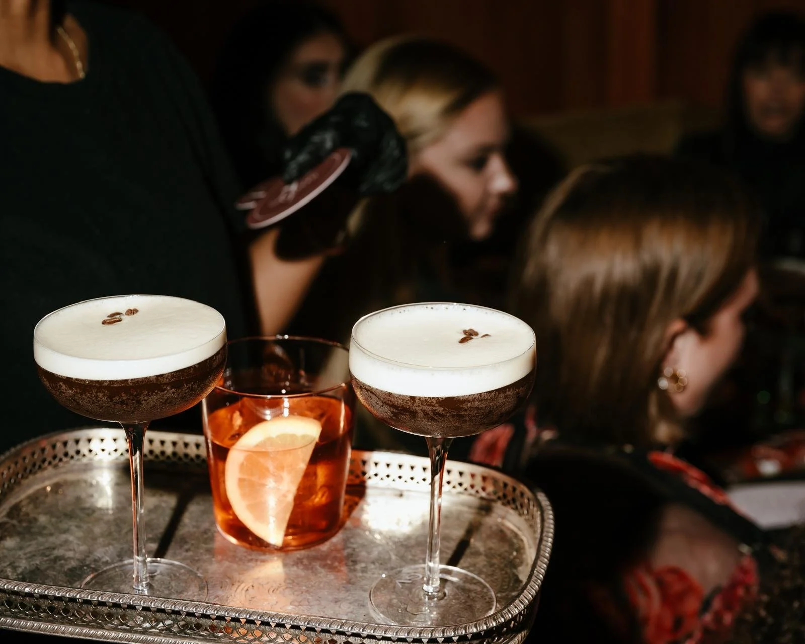 Two espresso martinis, and a glass of pink cocktail with a lemon wedge, in the PearlBox private event space in SoHo