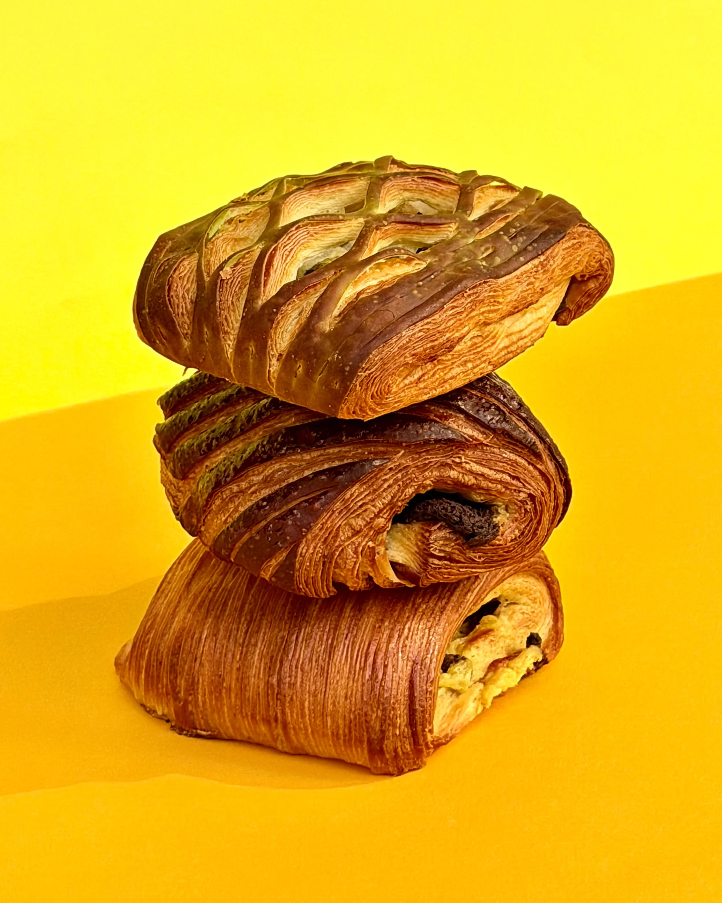 Stack of sliced beef wellingtons on a yellow background.