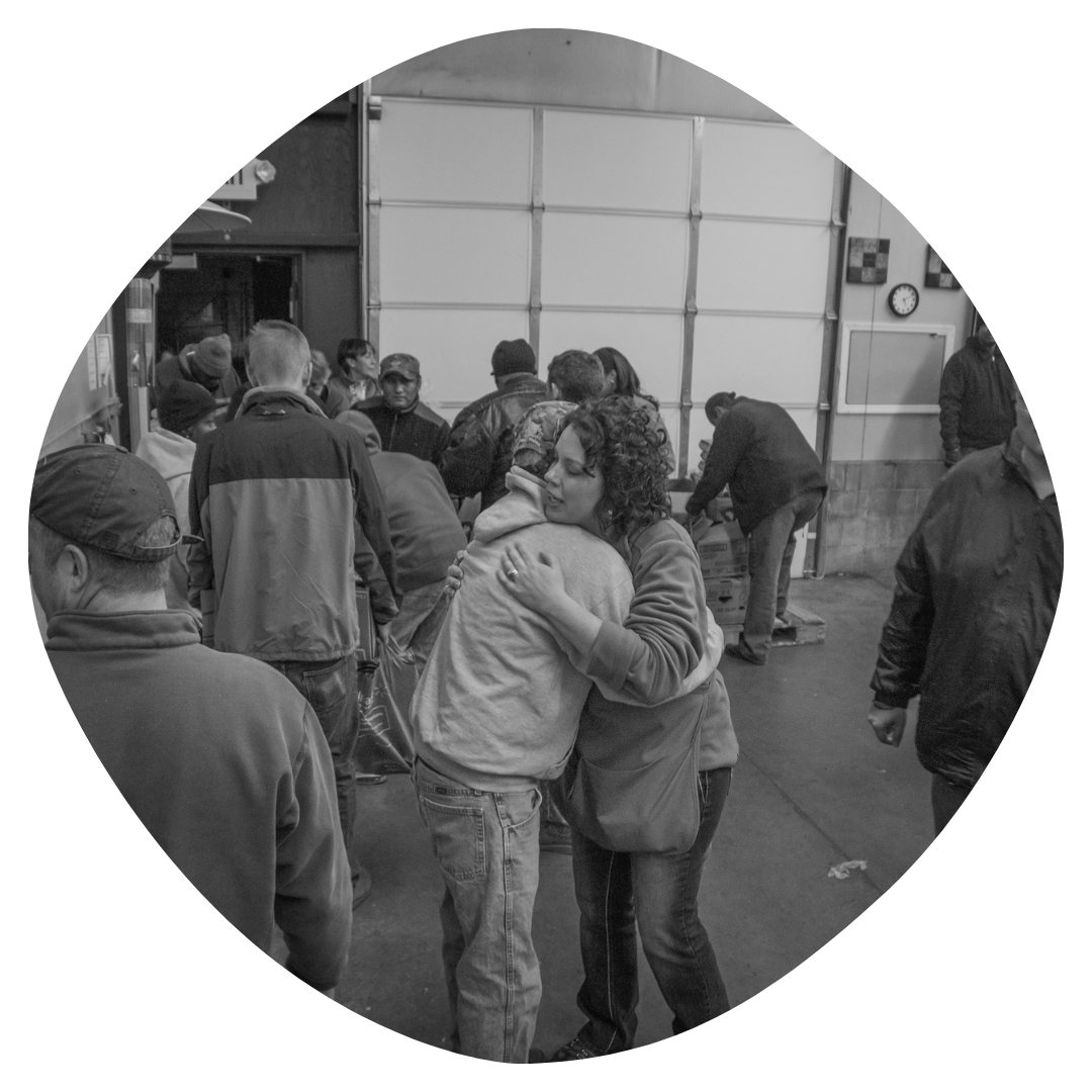 A woman singing passionately into a microphone on stage while kneeling, with her eyes closed and one arm raised. In the background, a band plays musical instruments against a starry backdrop.