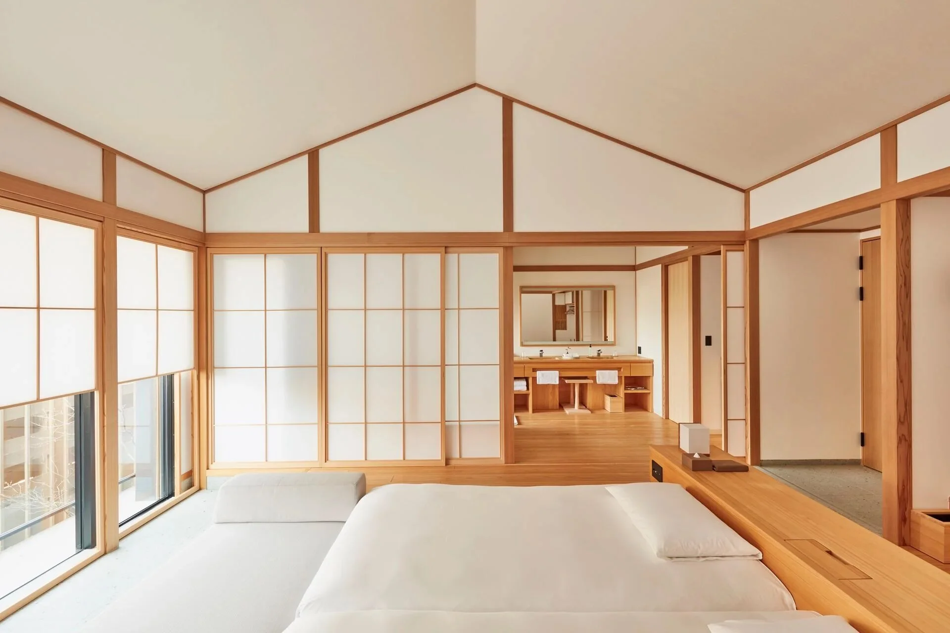 Modern bedroom with shoji screen walls, wood accents, large window, and a bed with white bedding.
