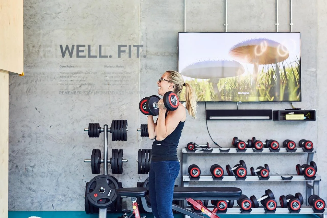 A woman in a gym with dumbells