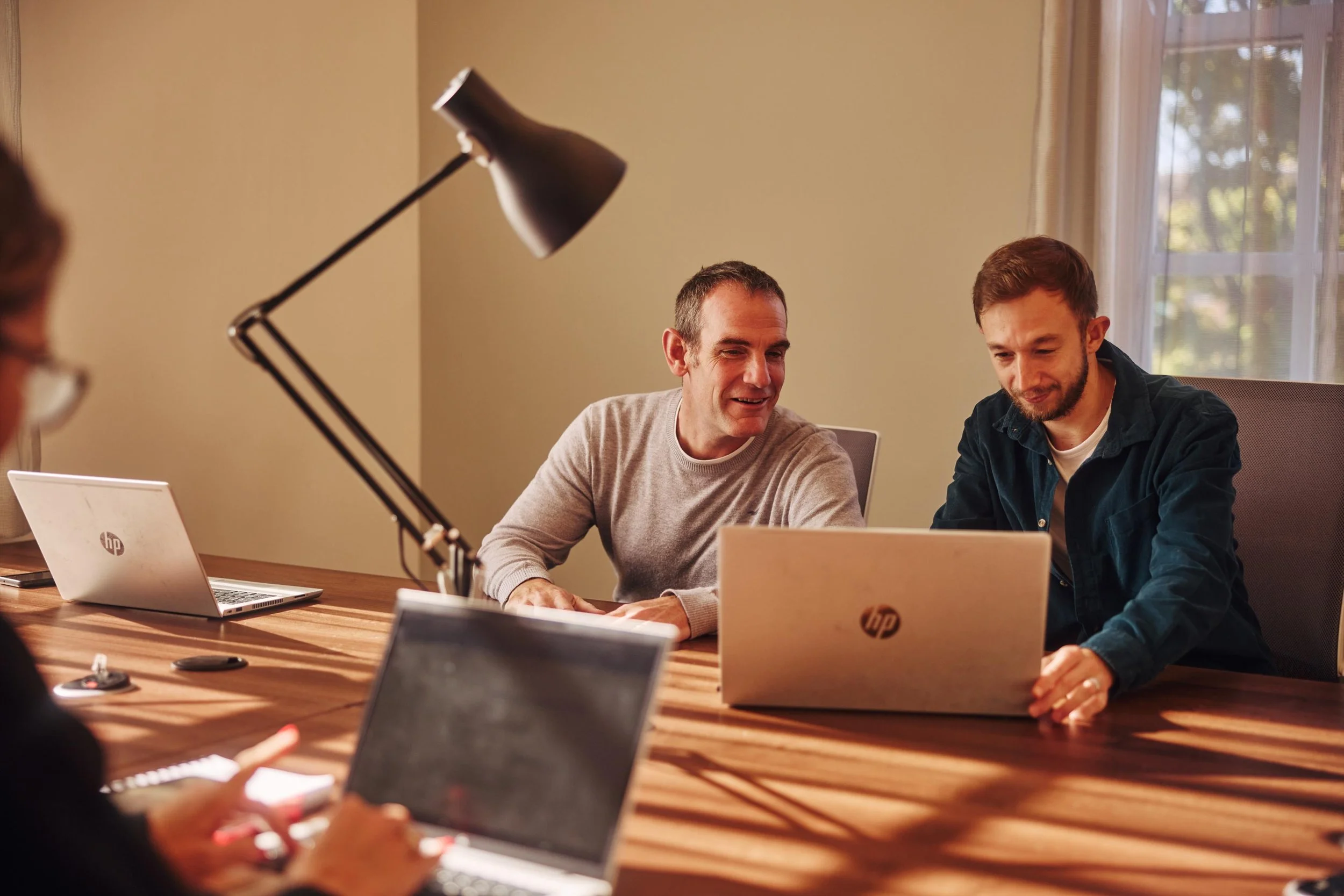 Two Unify team members working at a laptop