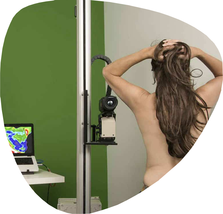 Client positioned for a thermal imaging session with infrared camera equipment and live thermal display, demonstrating the clinical setup used during a Body In Focus Thermography appointment.
