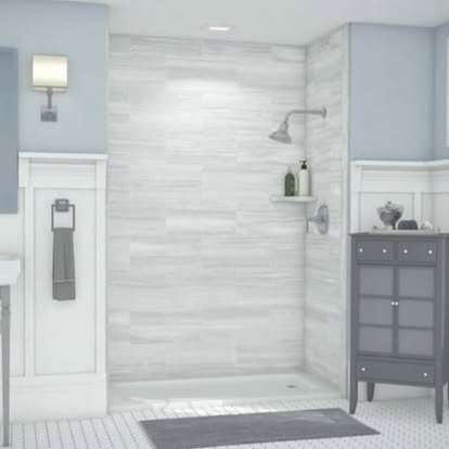 Bright bathroom featuring a walk-in shower with a handheld showerhead, a small shelf with a bottle, a dark gray cabinet with drawers, a white wall sconce, and a blue wall.