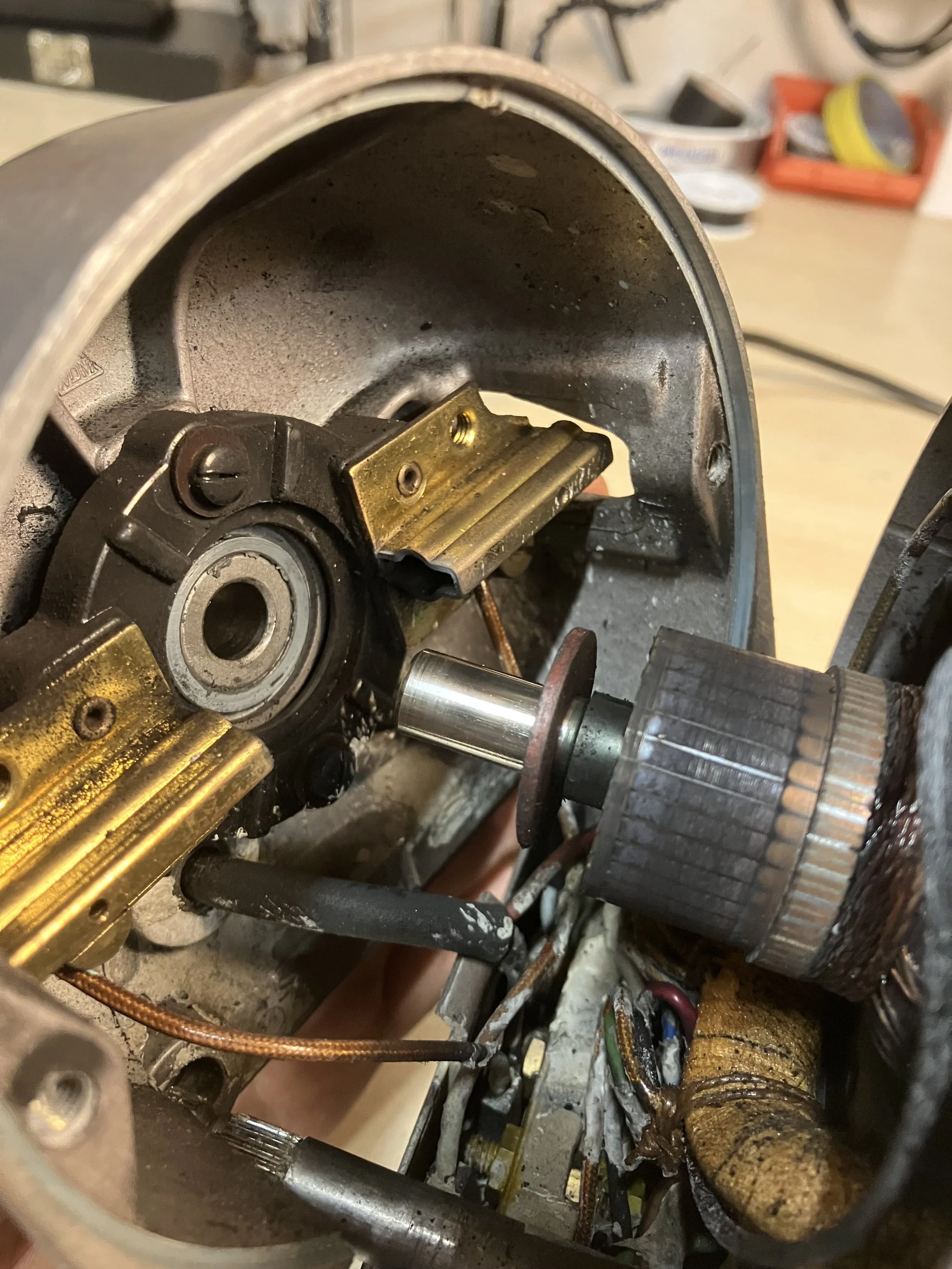 Geöffneter Motor einer Industrie-Nähmaschine. Zu sehen sind der Rotor mit den Kommutatorkontakten sowie die Halterungen für die Motorkohlen.