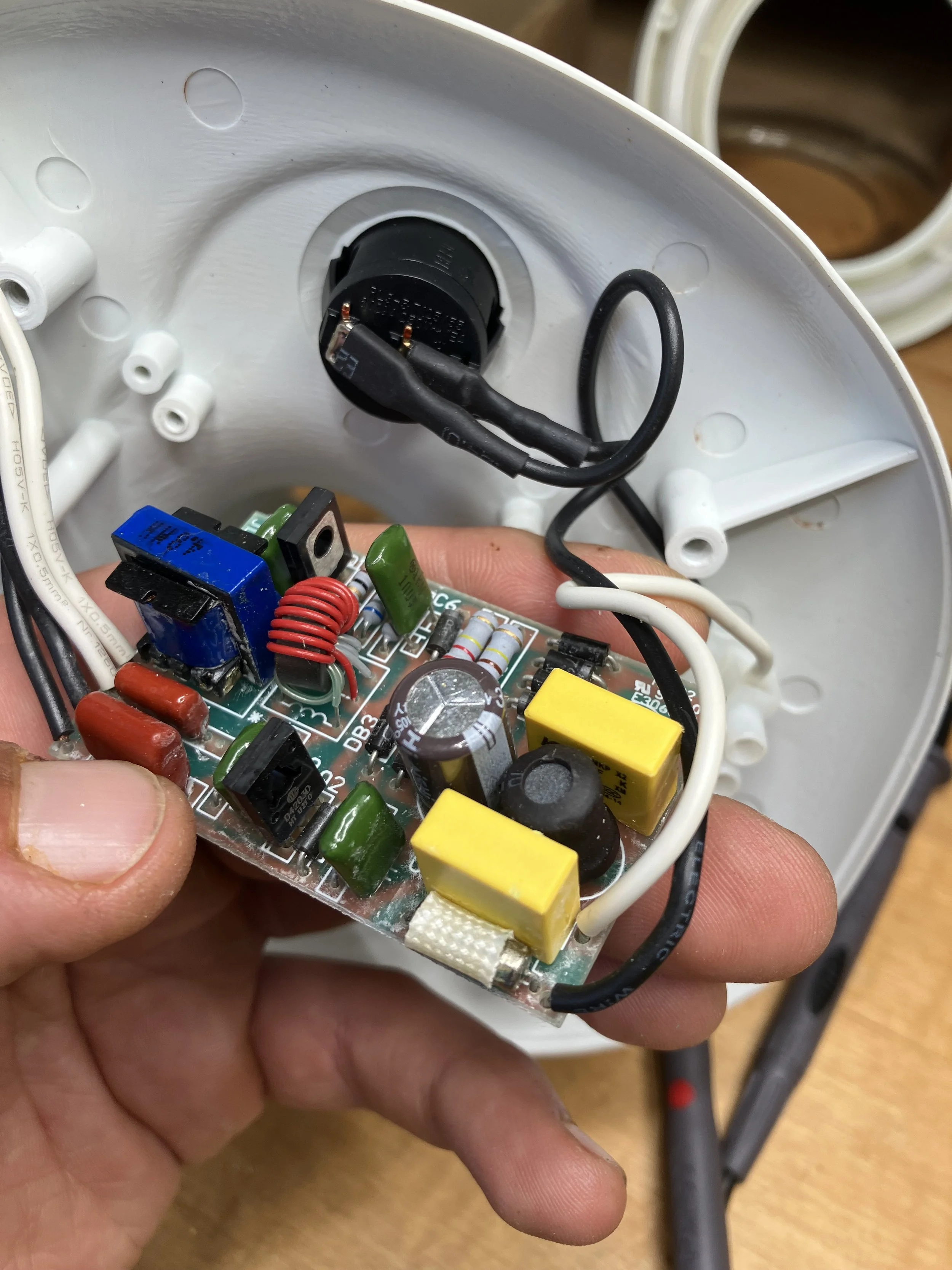 Netzteil einer Lupenlampe. Zu sehen sind eine Sicherung, Kondensatoren und Spulen sowie andere elektronische Bauteile.