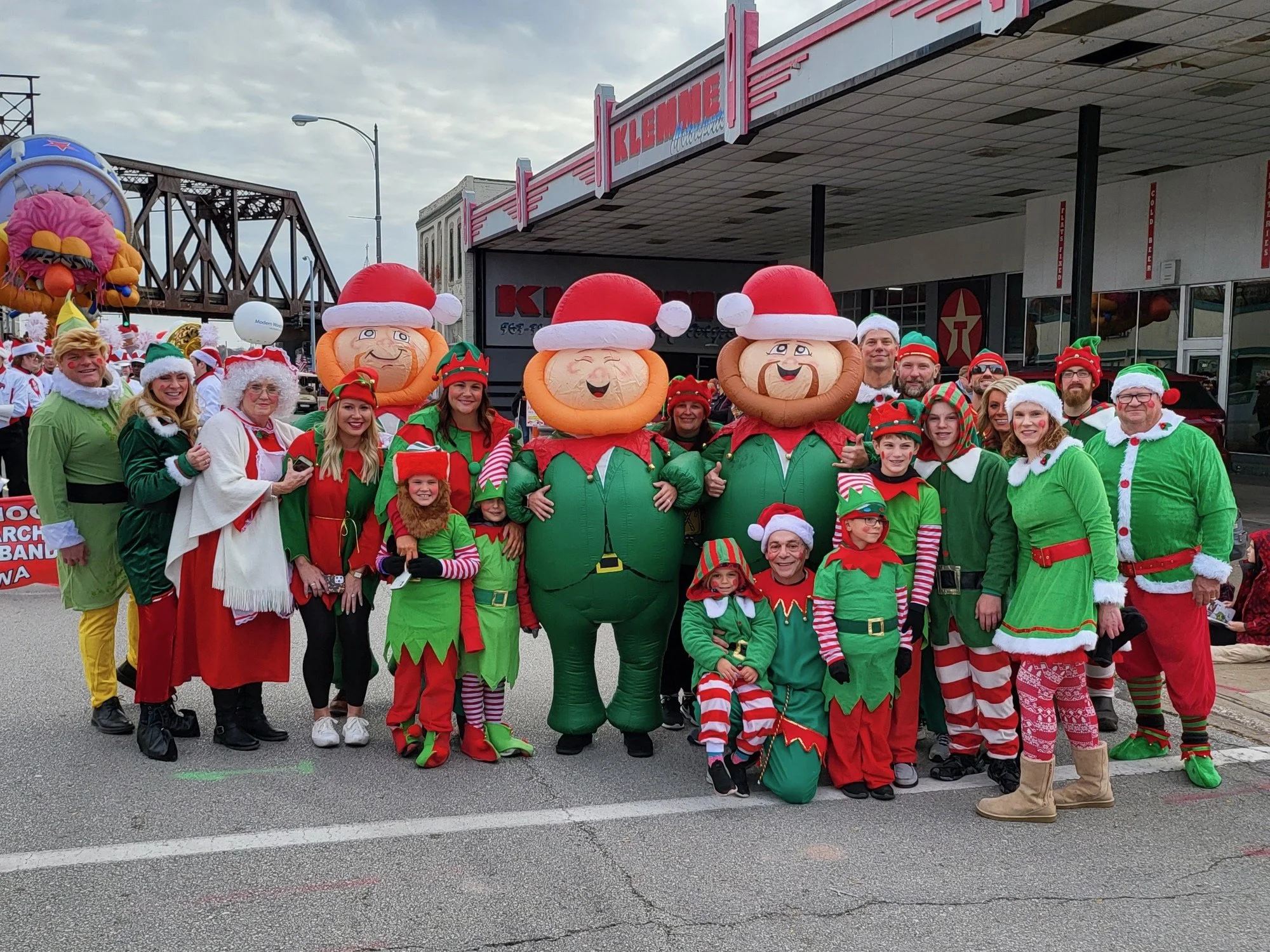 Group of people dressed as Christmas elves participating in the Festival of Trees parade in Davenport, IA.