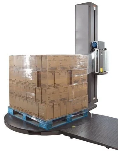 Automated pallet wrapping machine wrapping a pallet of boxes on a warehouse floor.