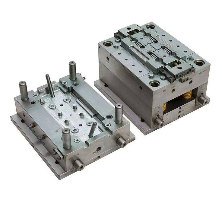 Two metal molds or dies used for manufacturing, featuring various pins, rails, and intricate mechanical parts.