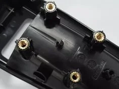 The inside of a black plastic device casing with five gold-colored screw terminals or connectors.