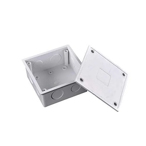A white plastic electrical outlet box with an open lid, showing mounting holes inside.