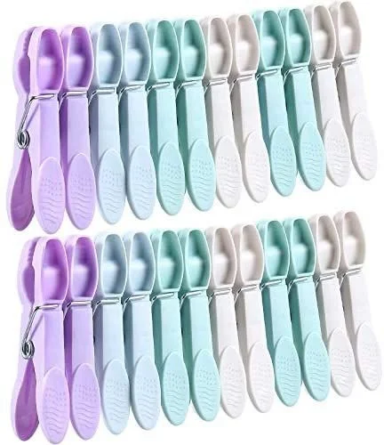 Multiple baby nail clippers in pastel purple, blue, green, white, and cream colors arranged in rows.